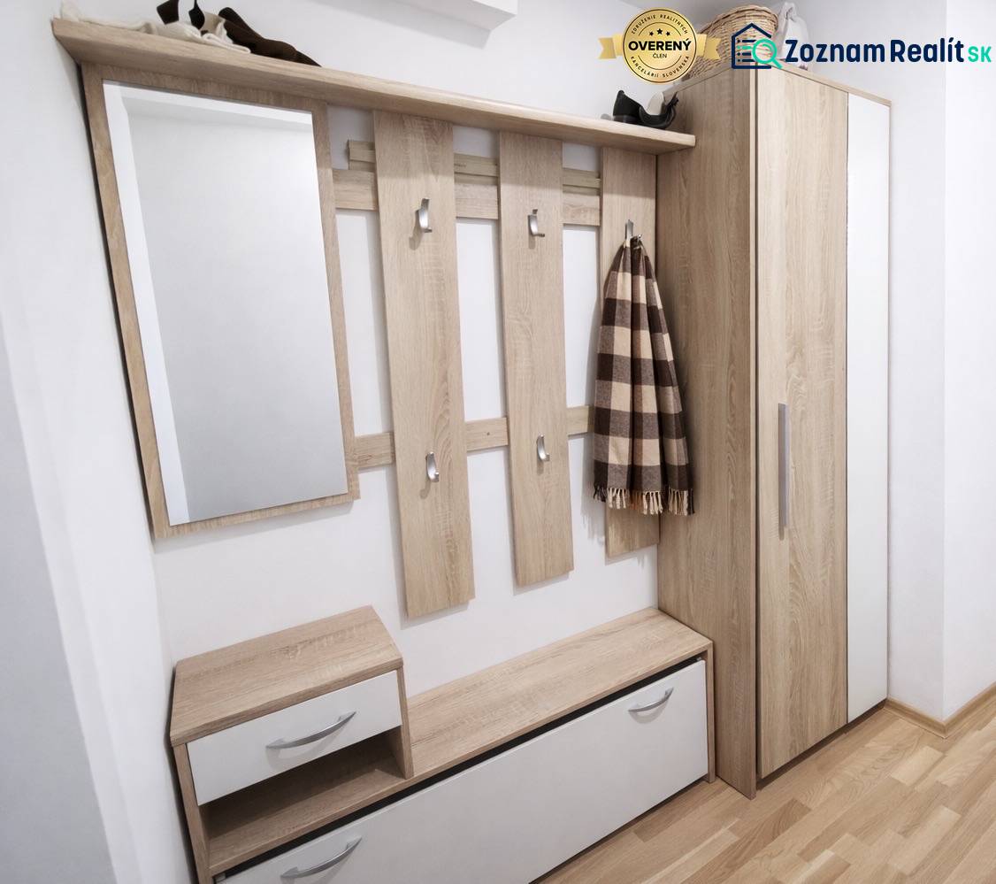 Entrance hallway in a 2-room apartment with wood-patterned flooring and storage space.