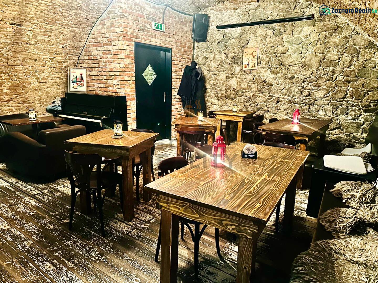 Gastro premises with stone walls, a piano, and a floor with a wooden decor.