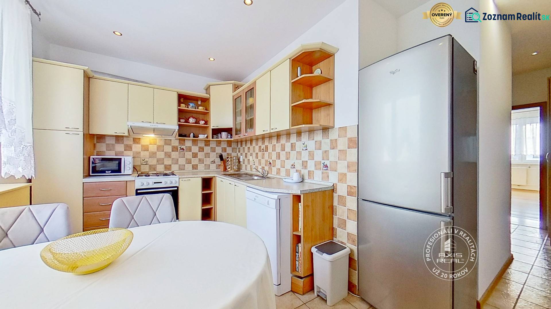 A kitchen in a 3-room apartment with a cream-colored kitchen unit and patterned tiles.