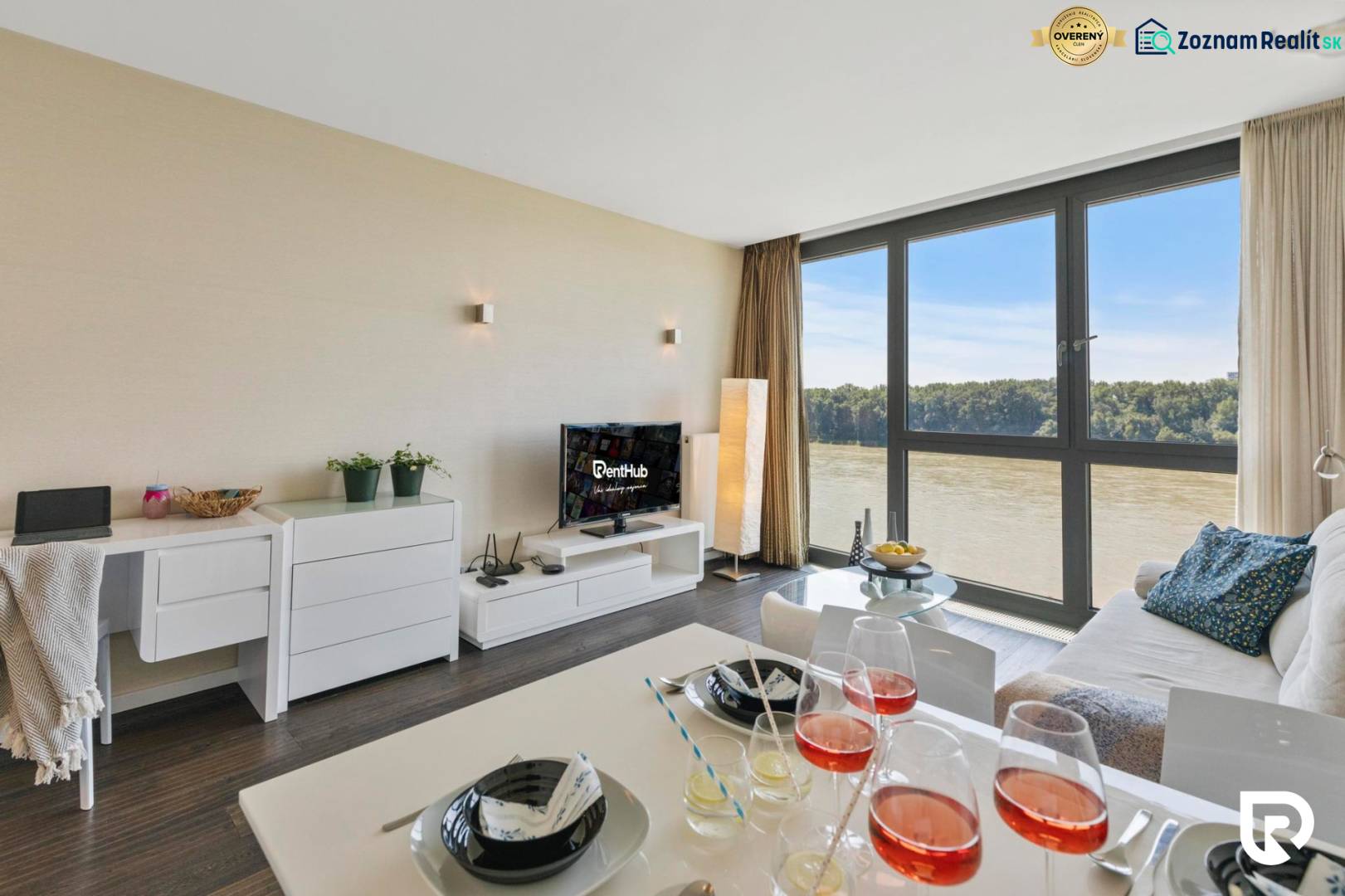 Living room in a two-room apartment with a view of the river and a floor with a wooden decor.