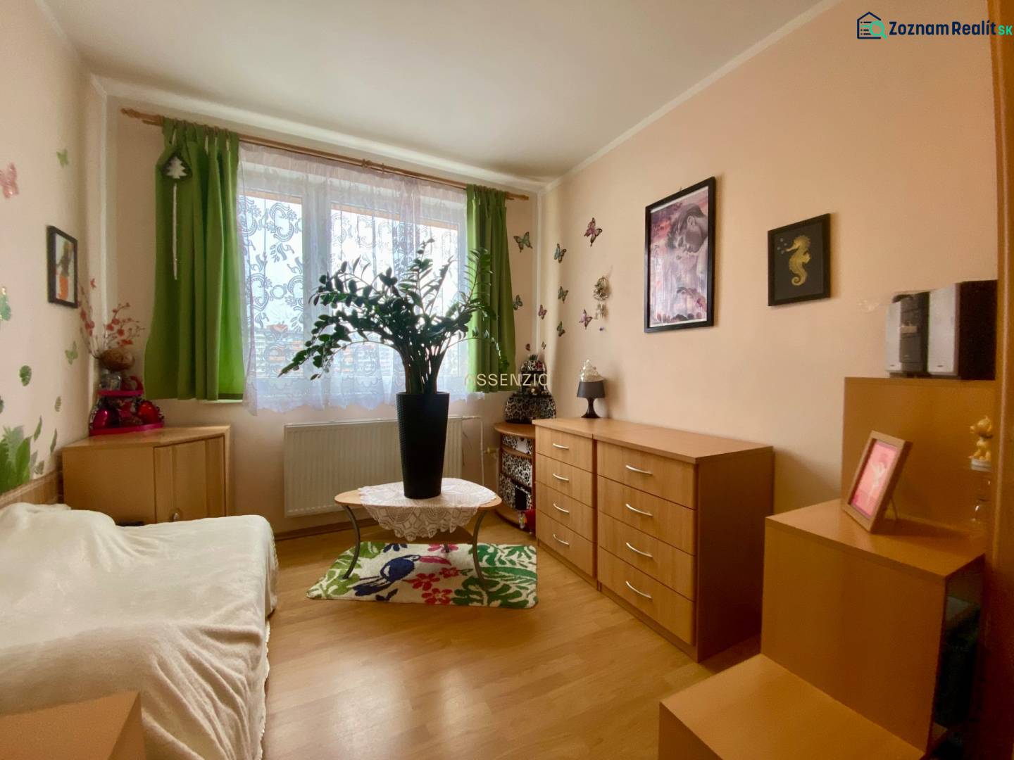 A room in a 3-room apartment with decorations, wooden dressers, and a wooden decor floor.