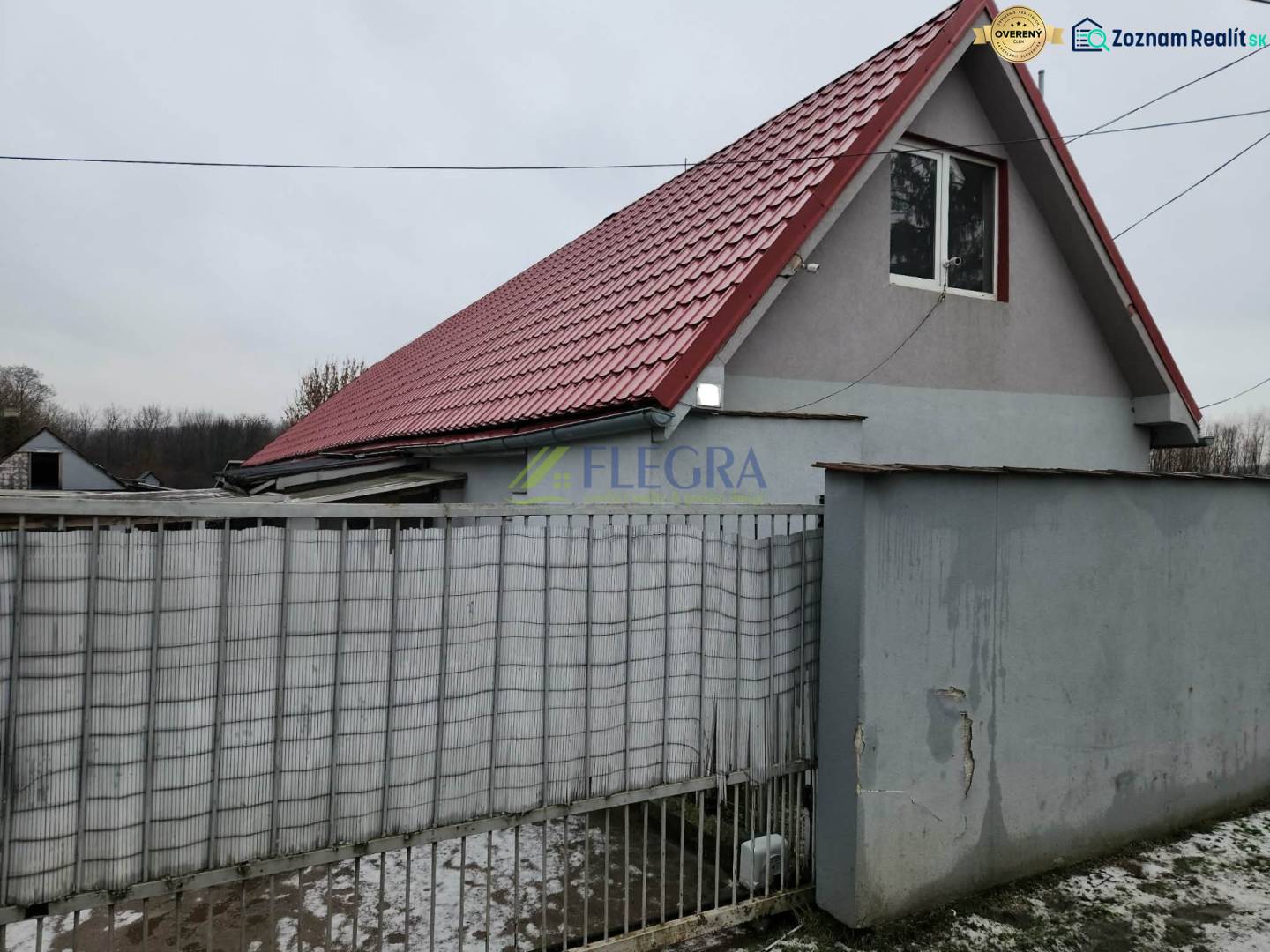 A family house in Tornyosnémeti with a red roof and a gray fence.