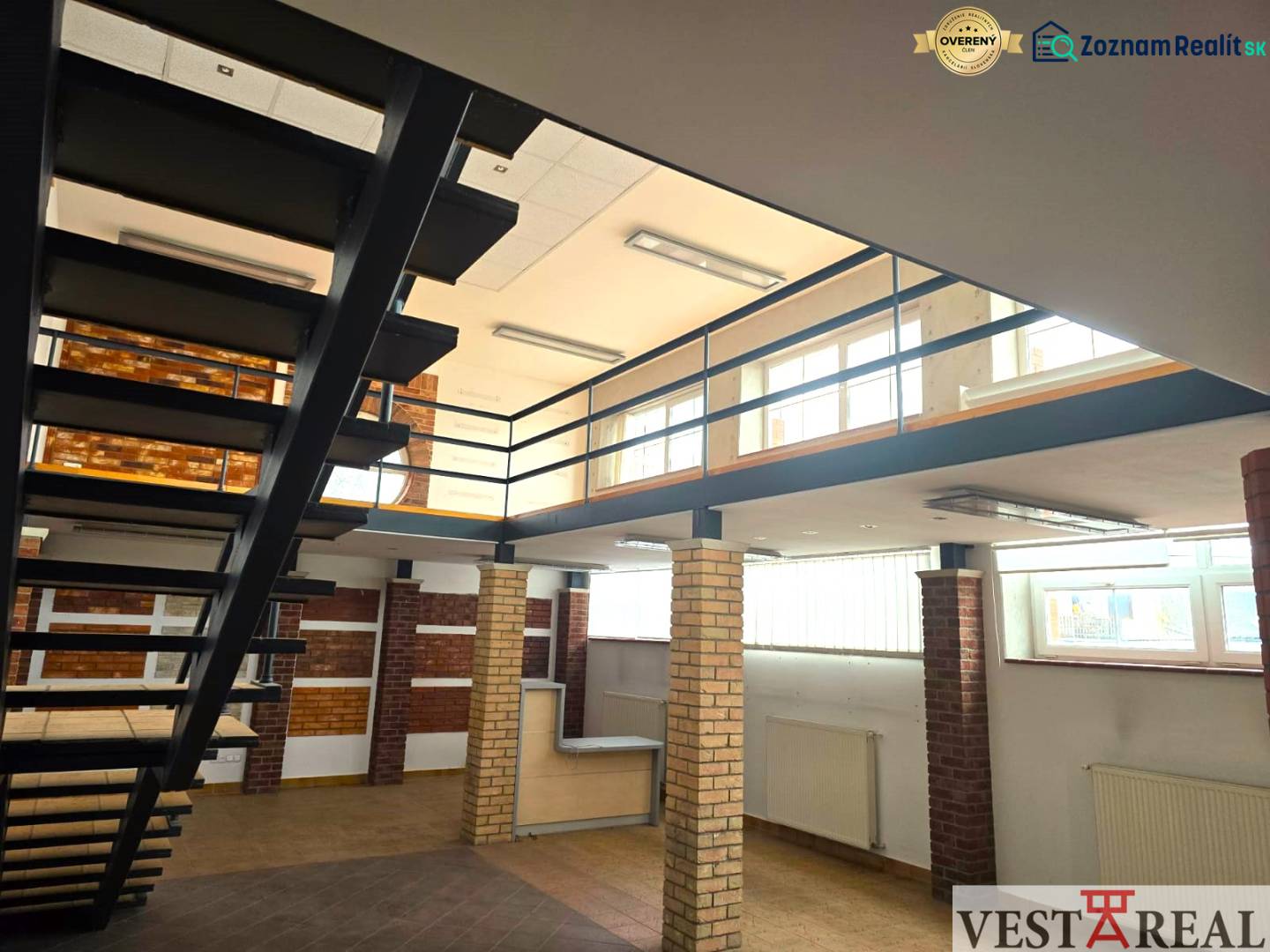 Interior commercial spaces with wood-patterned flooring and metal staircase.