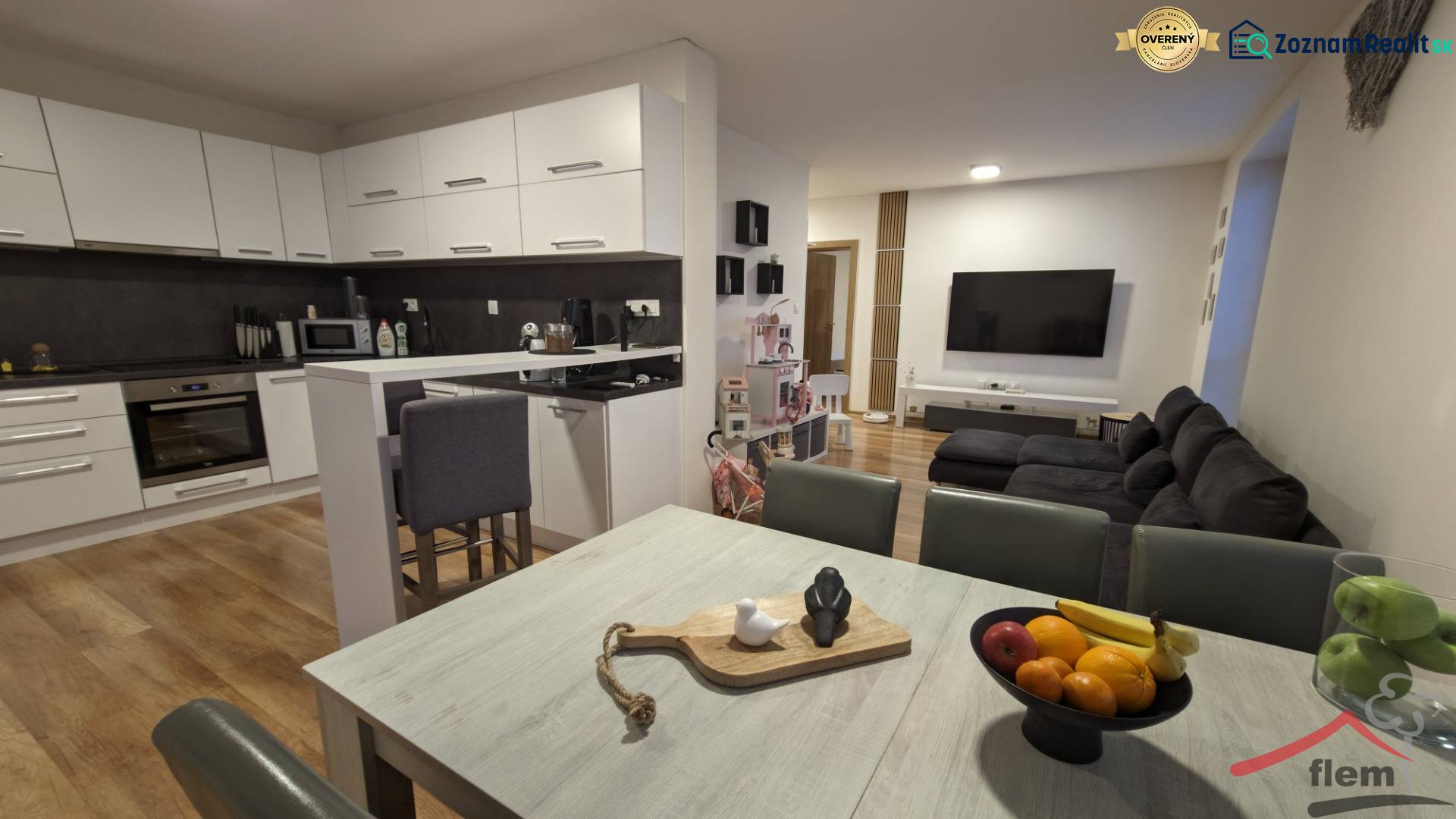 Kitchen with living room in a 2-room apartment, light cabinetry, floor with wood decor.