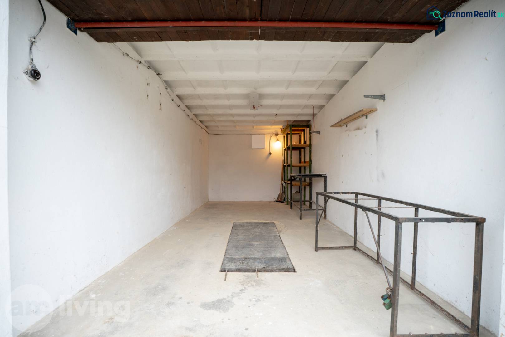 Spacious garage interior with metal shelves and white walls.