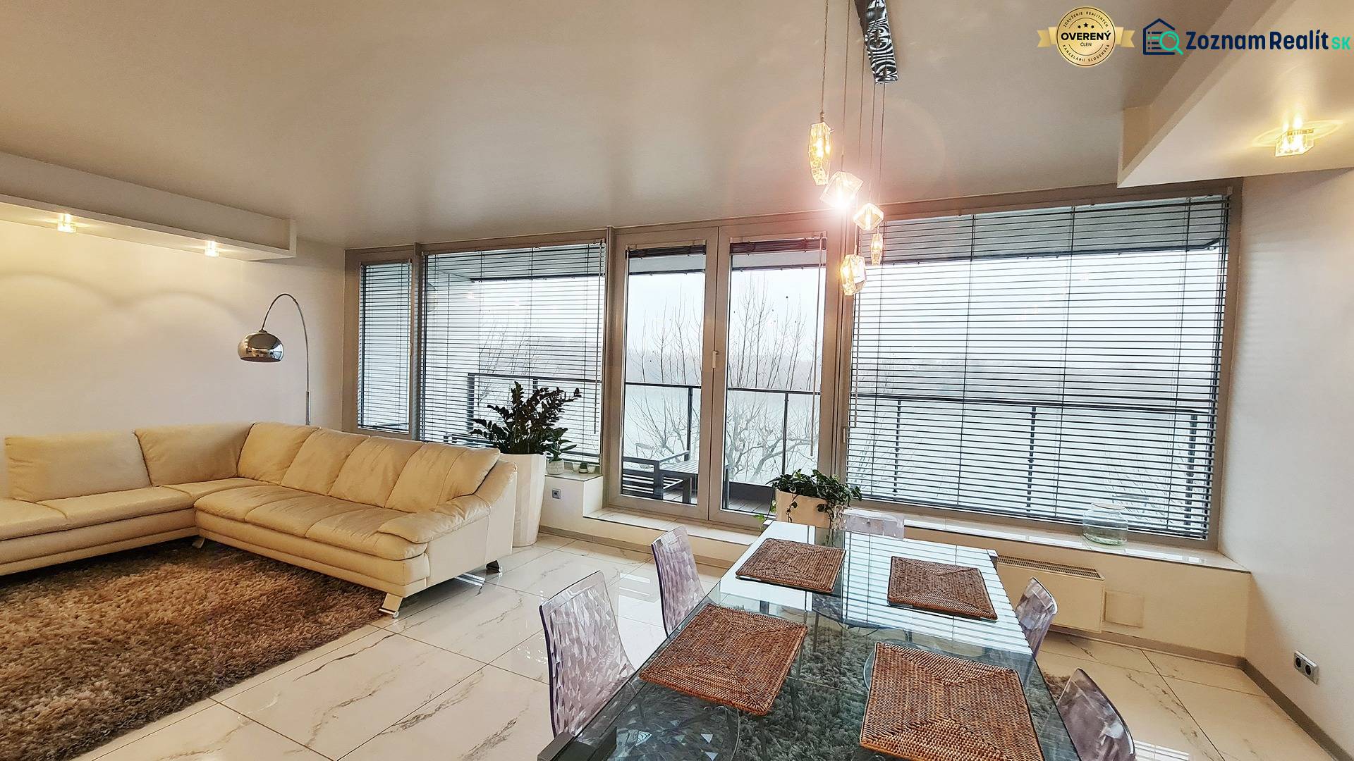 Living room in a three-room apartment with a light sofa, table, and glass doors.