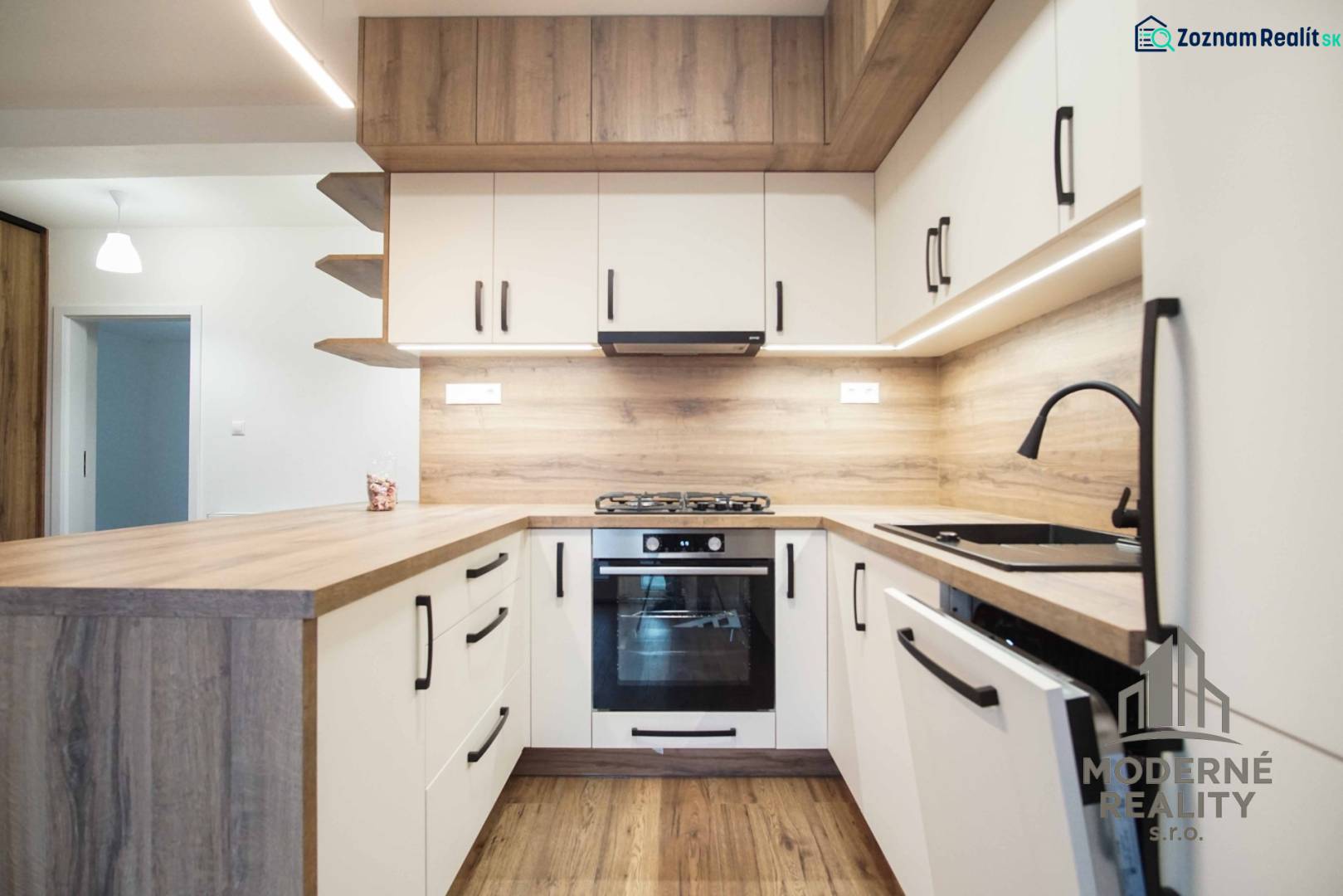 A kitchen in a family house with white cabinets and a wooden decor floor.