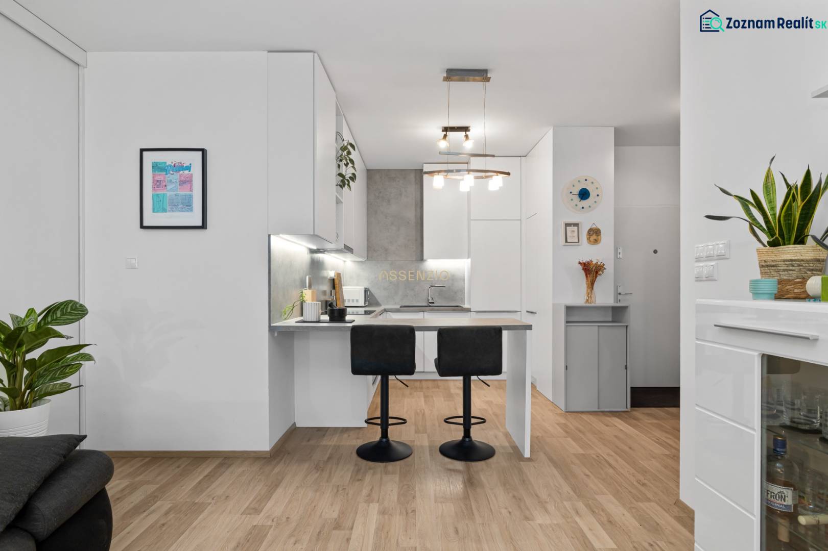 A kitchen in a 3-room apartment with a bar counter and a floor with a wooden decor.
