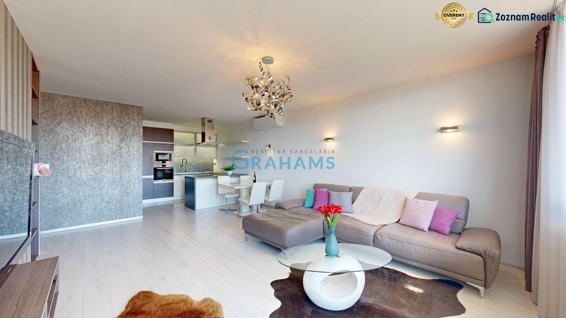 Living room in a 3-room apartment with a wooden decor floor, light walls, and a sofa.