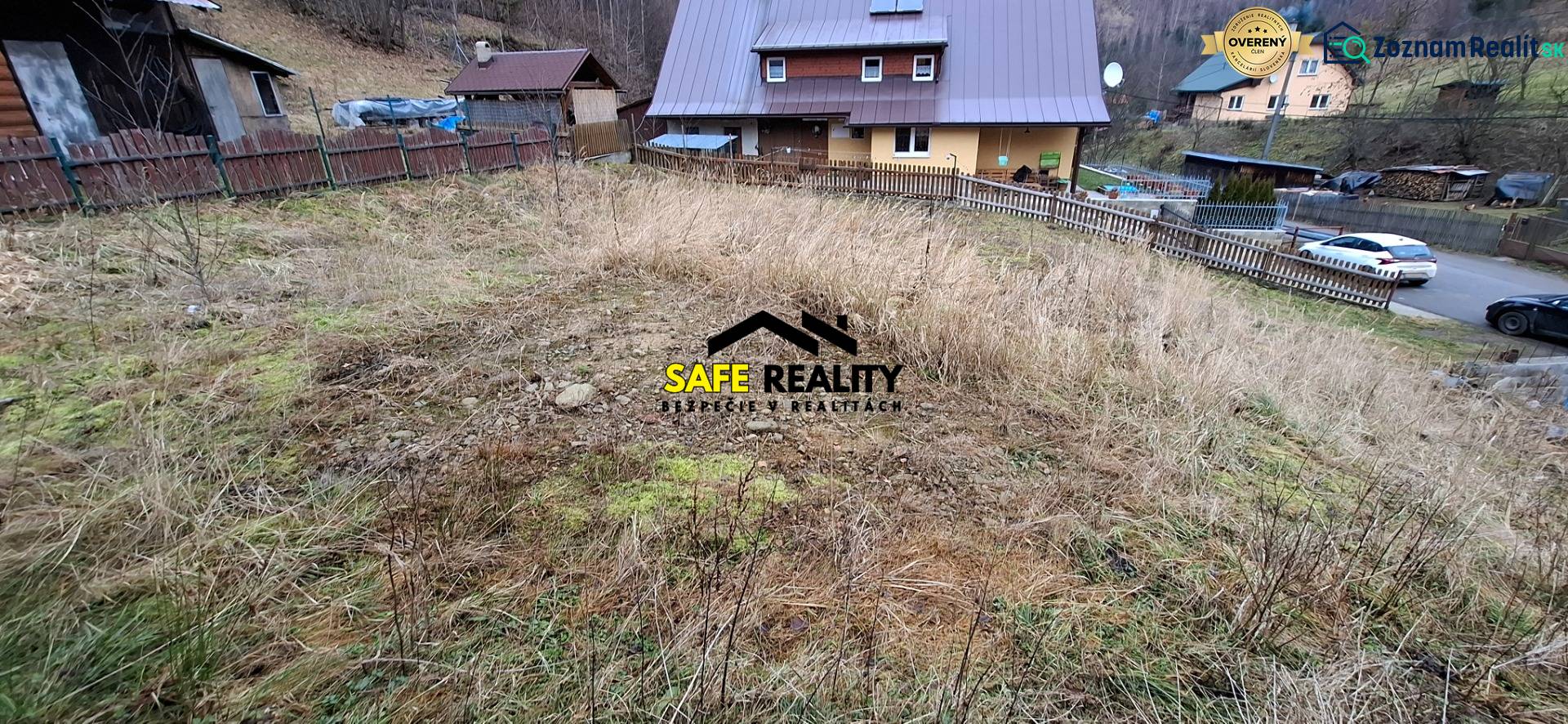 A plot of land for residential use in Oščadnica with a sloping terrain and neighboring houses in the background.
