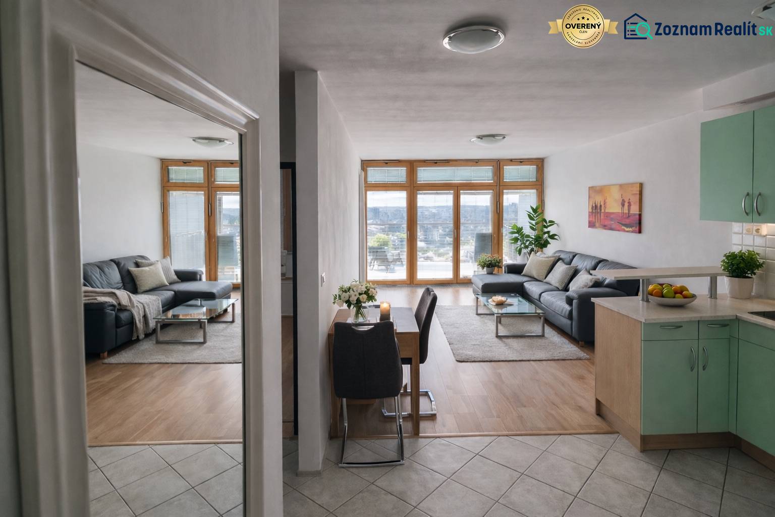 Living room in a two-room apartment with a wood-patterned floor and a comfortable sofa.
