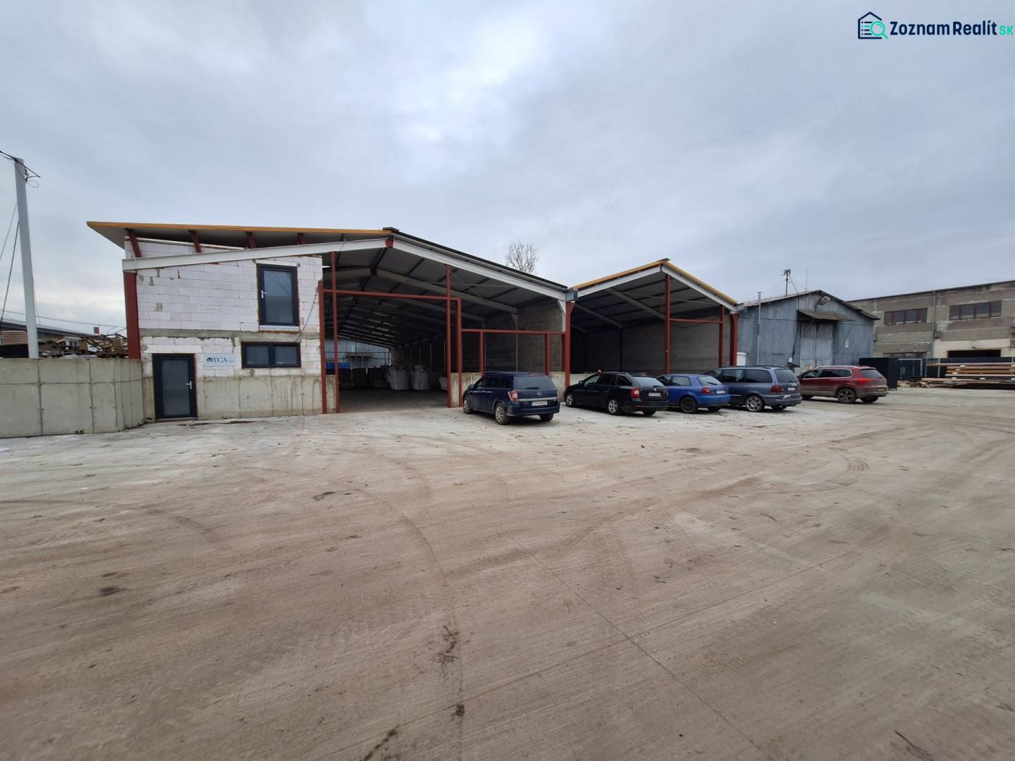 Warehouse and hall space on Strojnícka Street in Prešov with a parking lot and cars.