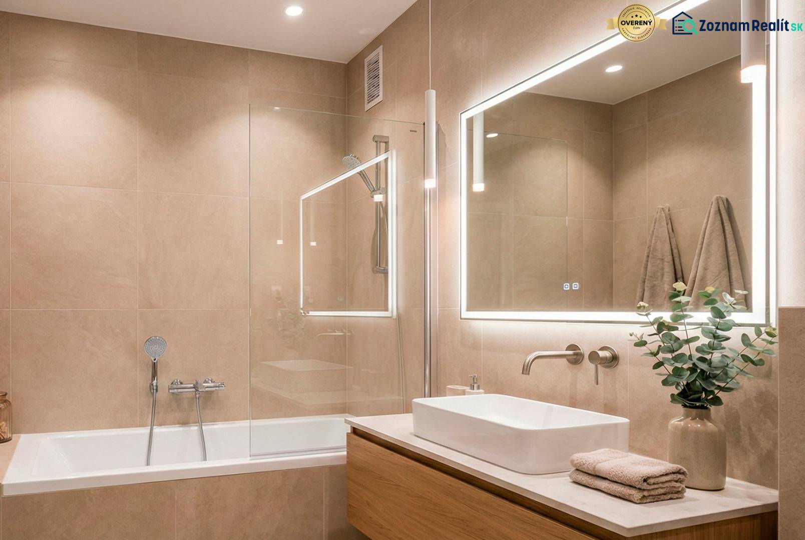 Bathroom in a 2-room apartment with a bathtub, mirror, and light tiles.