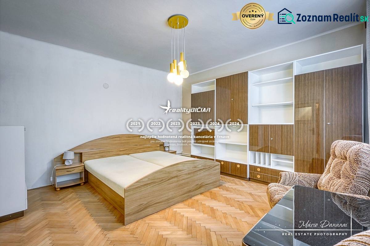 Bedroom in a family house with wooden flooring, a bed, and a built-in wardrobe.