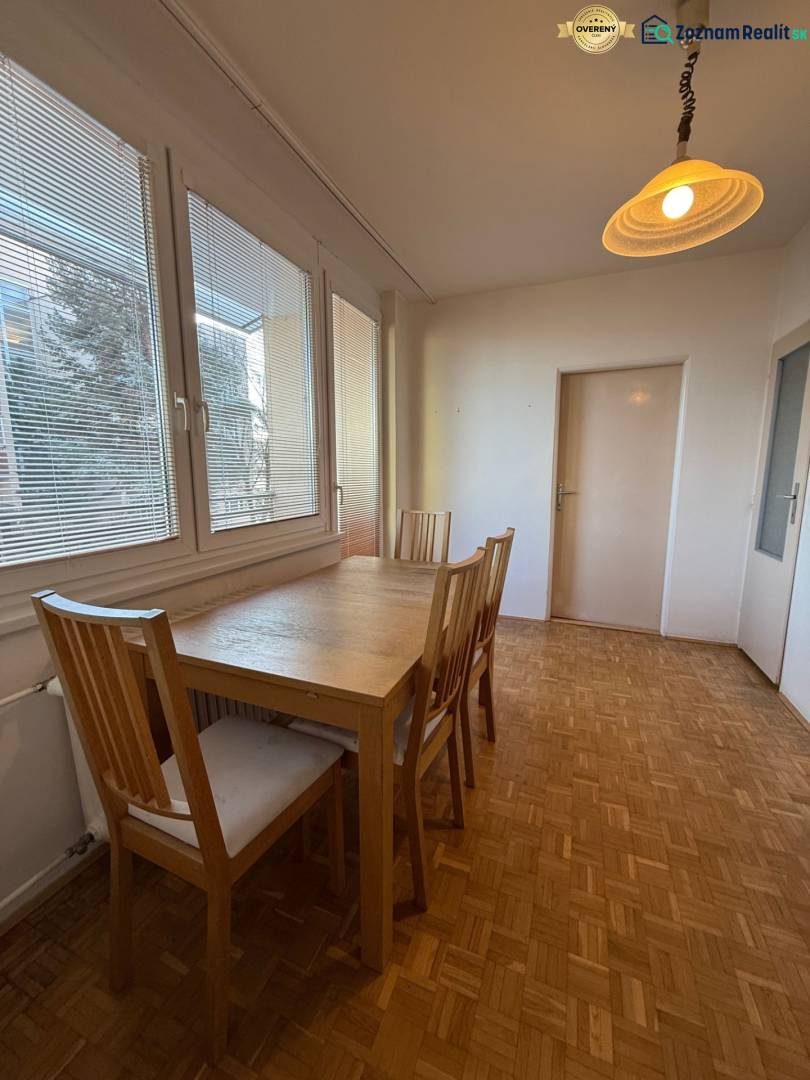 Dining room with a table and chairs in a 3-room apartment, floor with wood decor.