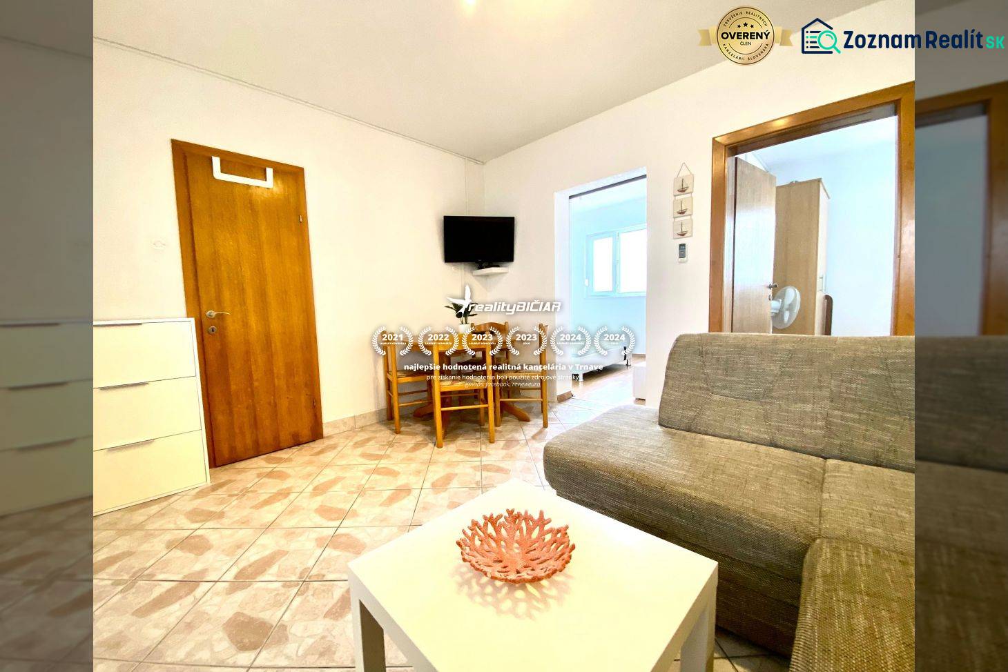 Living room in a family house with a sofa, a table, and a television on the wall.