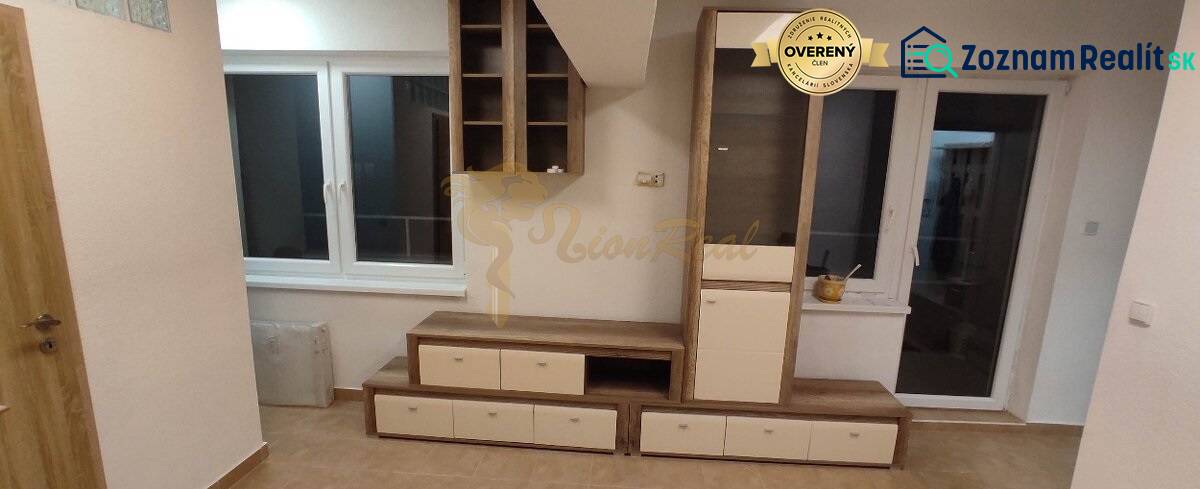 Living room in a studio apartment with furniture, a window, and a floor with a wooden decor.