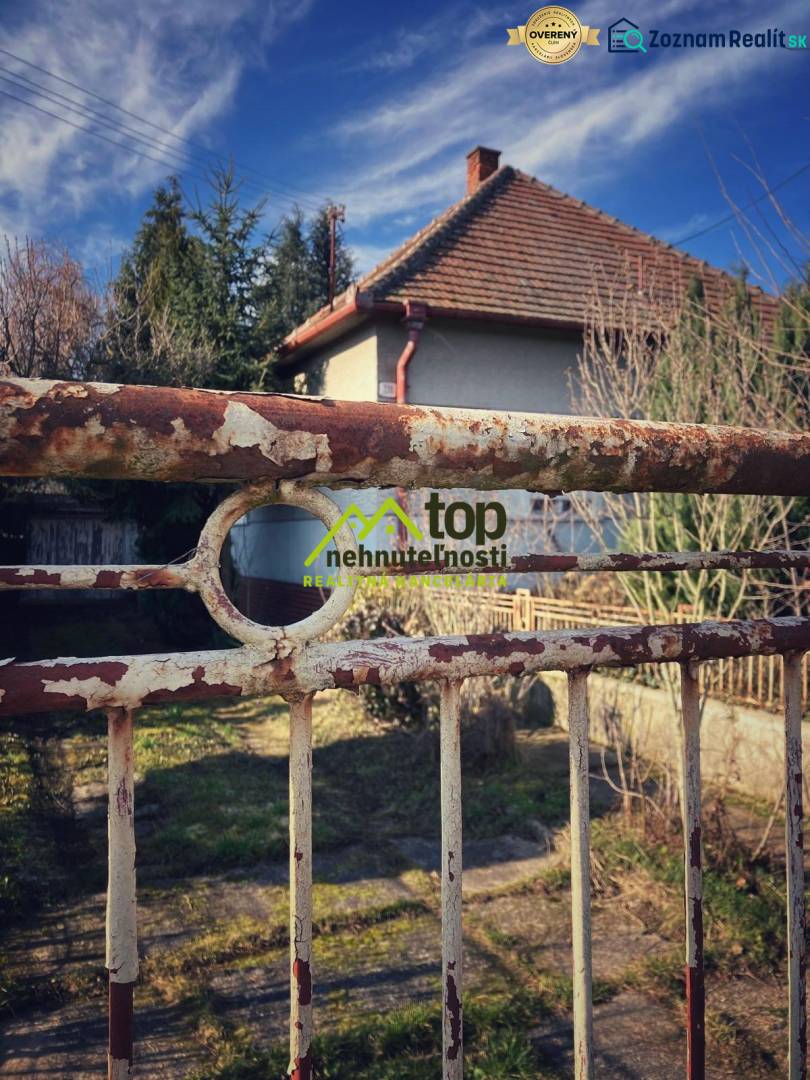 A family house in Horné Chlebany, fencing with a touch of patina, and a garden.
