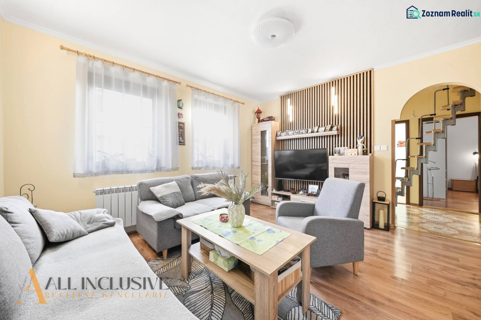 Living room in a family house with a sofa, table, television, and floor with a wooden decor.