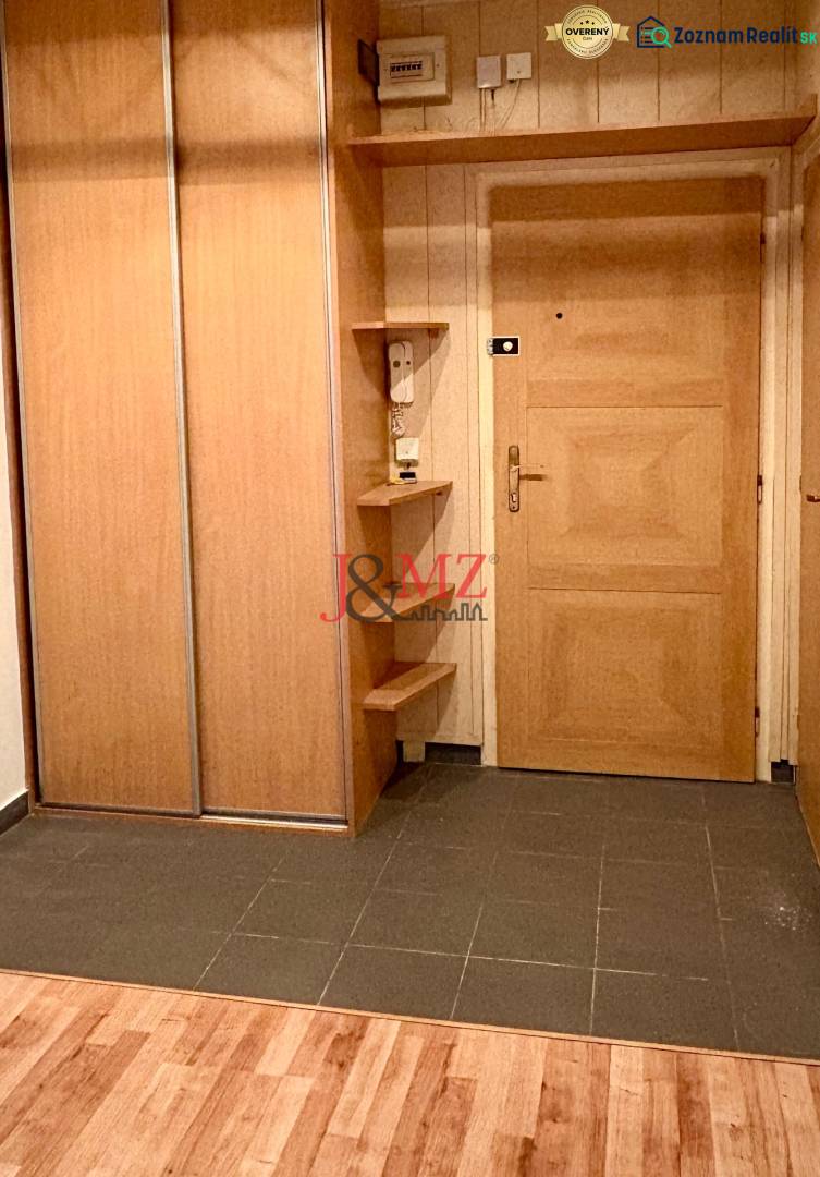 The entrance hall of a two-room apartment with a wooden decor floor and a spacious wardrobe.