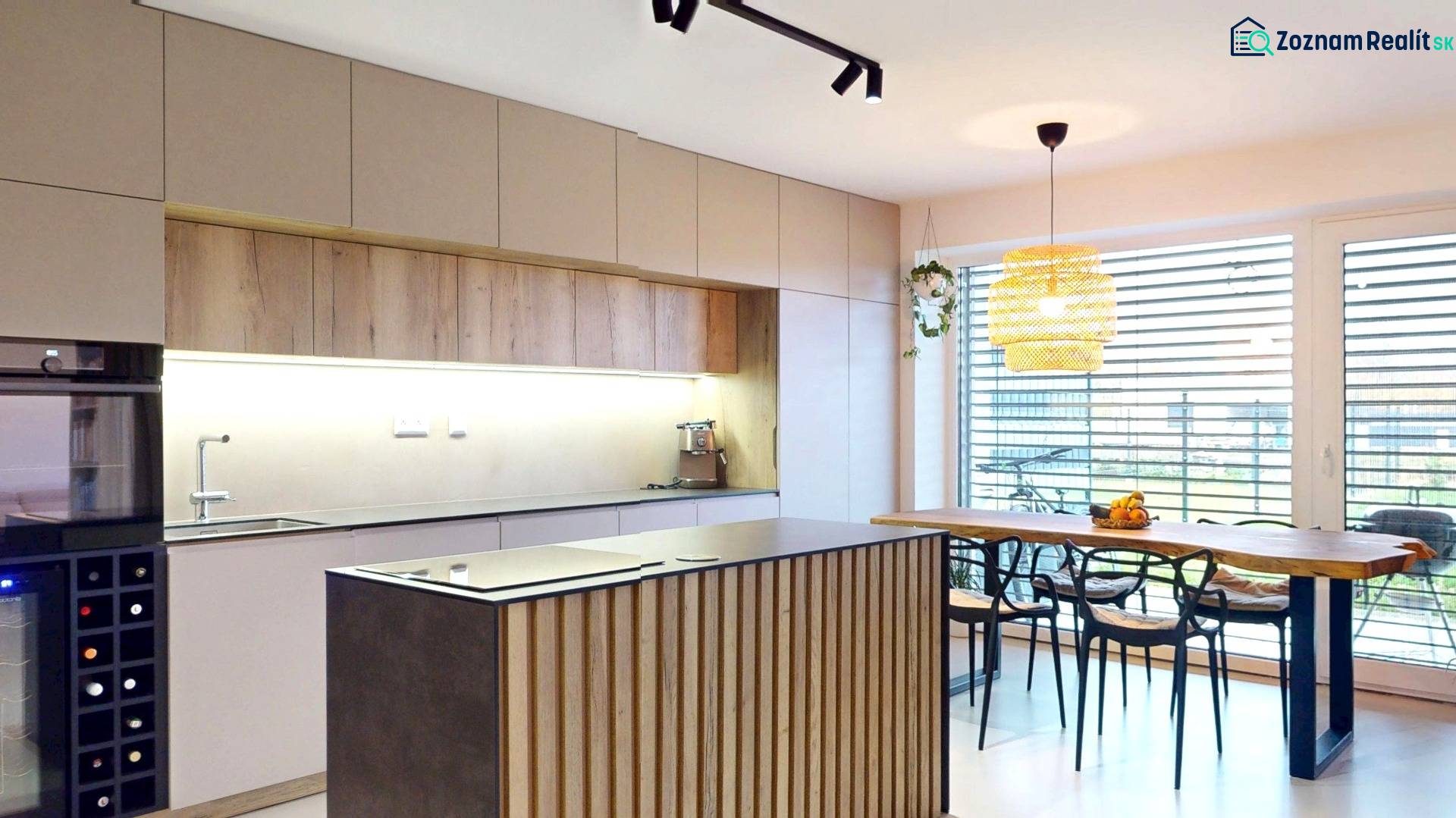 A kitchen in a family house with wooden decor furniture and large windows.