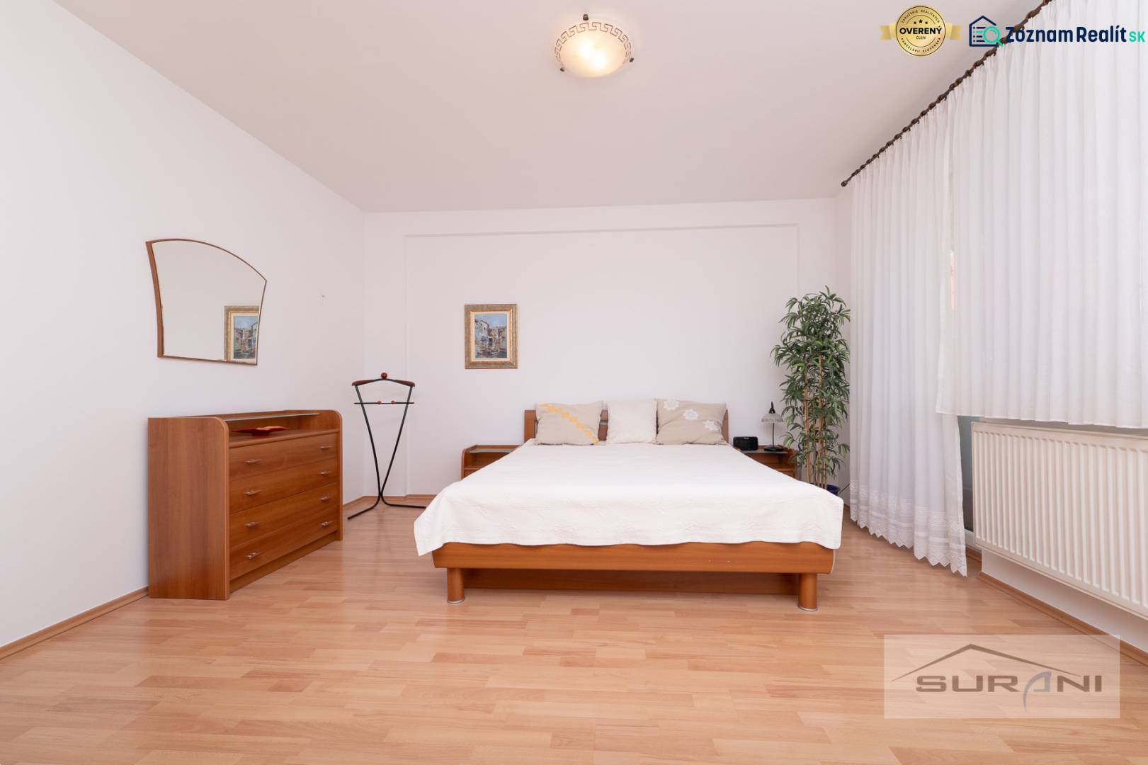 Bedroom with a bed, dresser, and wooden decor flooring in a three-room apartment.