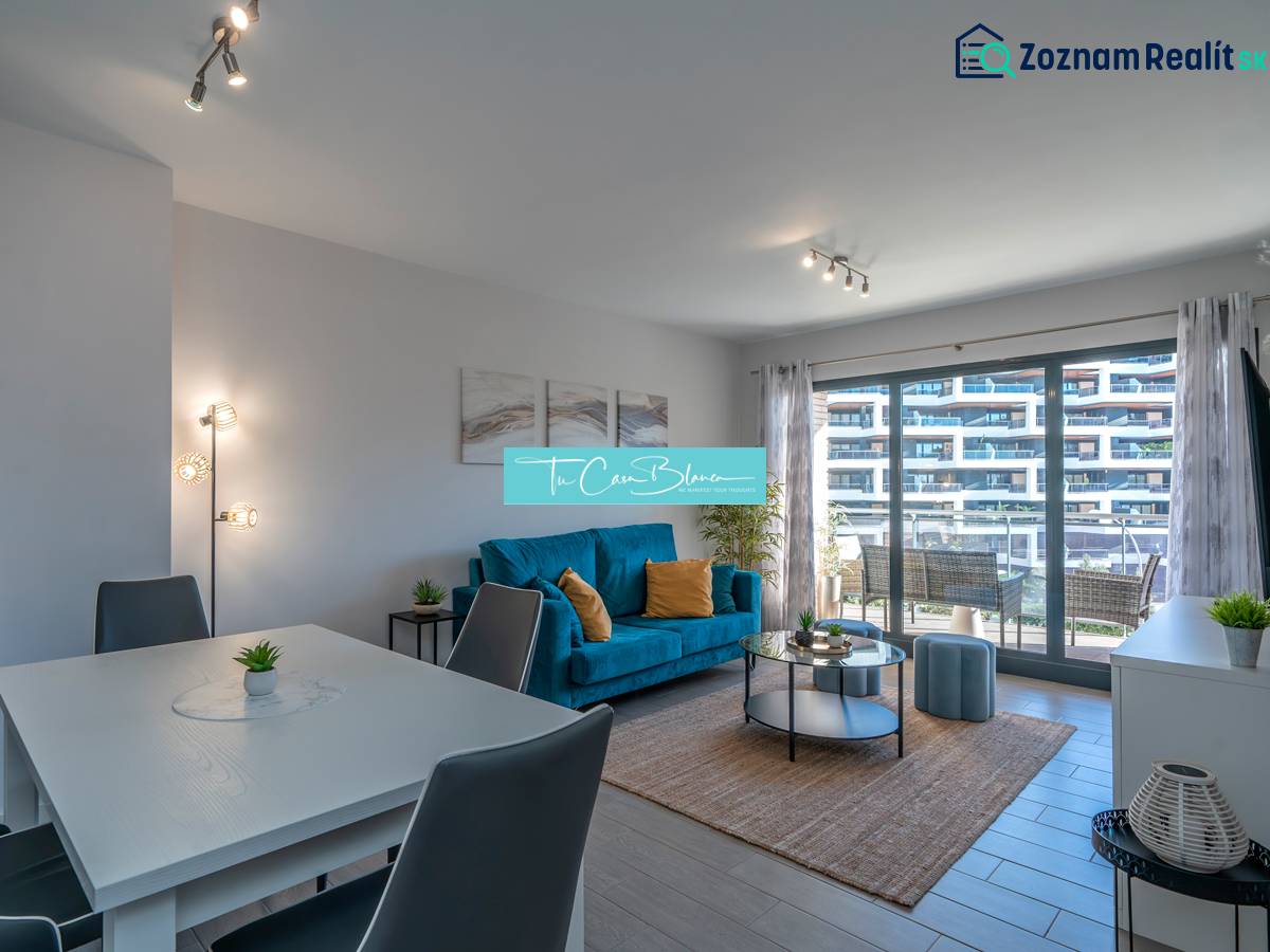 Living room in a two-room apartment with a wooden decor floor and seating area.