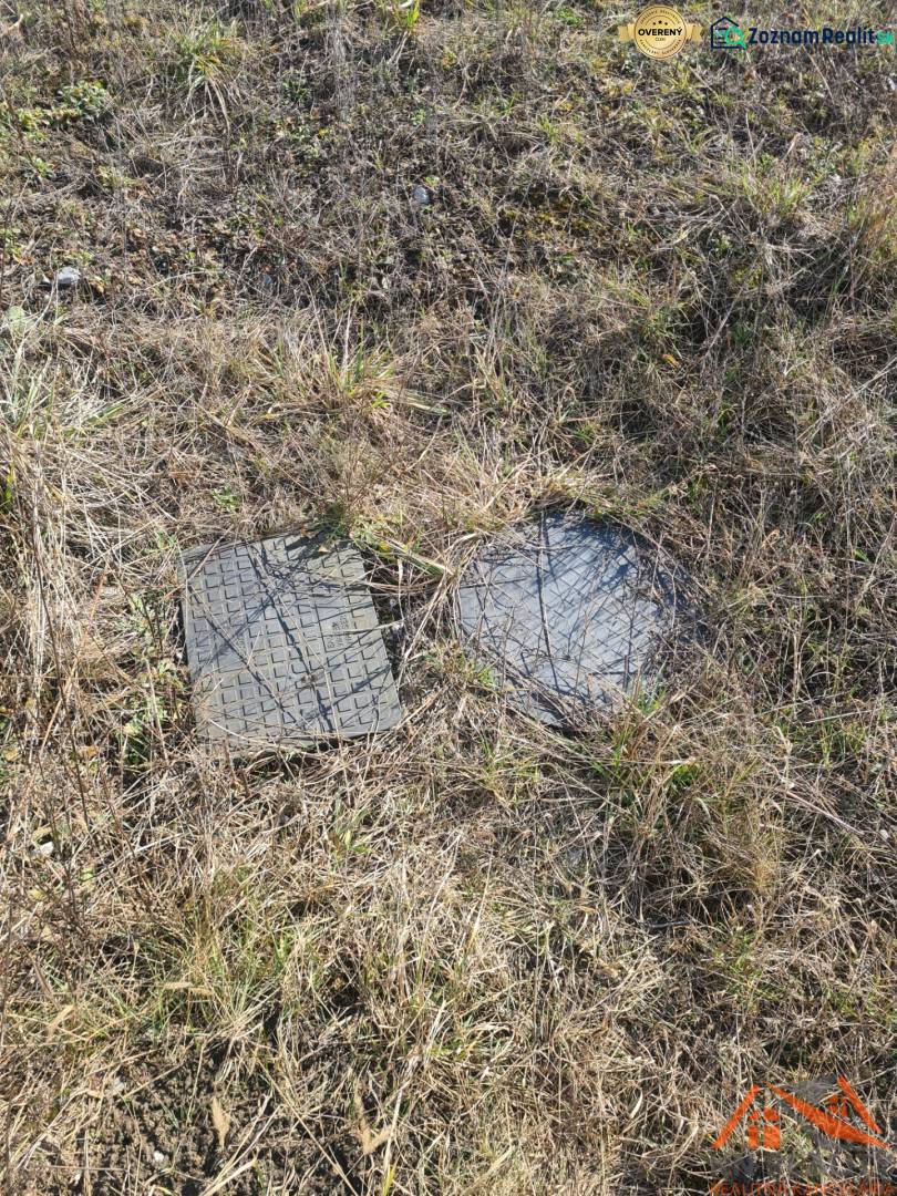 Plots - housing in Nové Zámky with manhole covers on the grassy area.
