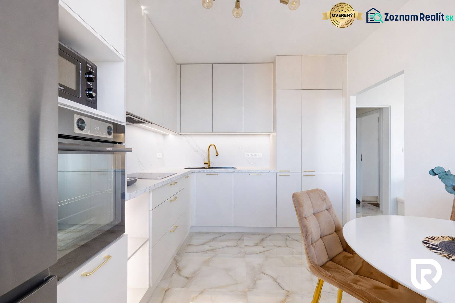 A kitchen in a 3-room apartment with white cabinets and a marble floor.