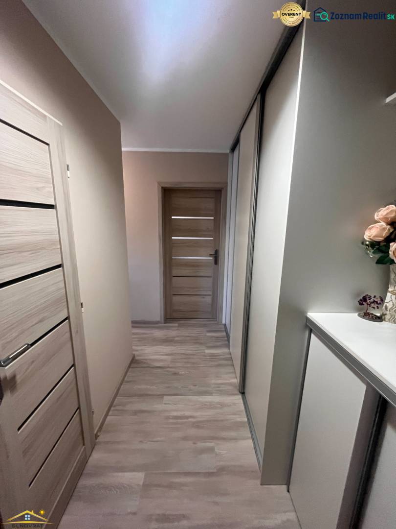 A hallway in a 3-room apartment with a wooden decor floor.