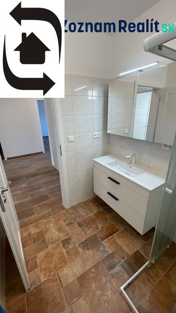 A bathroom in a family house with a wooden decor floor and a shower corner.