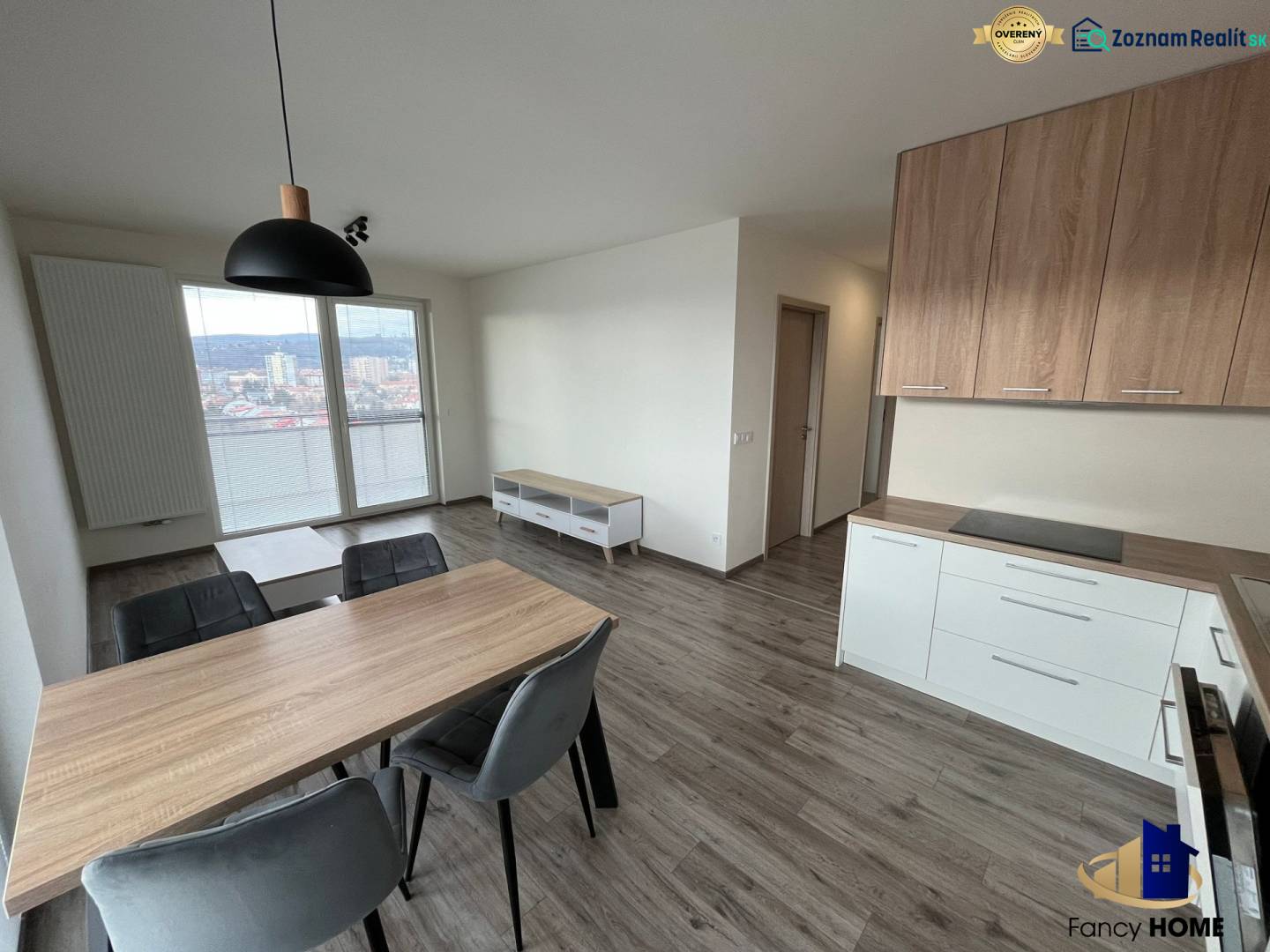 Dining area with wood-patterned flooring in a 3-room apartment, kitchen unit, and view.