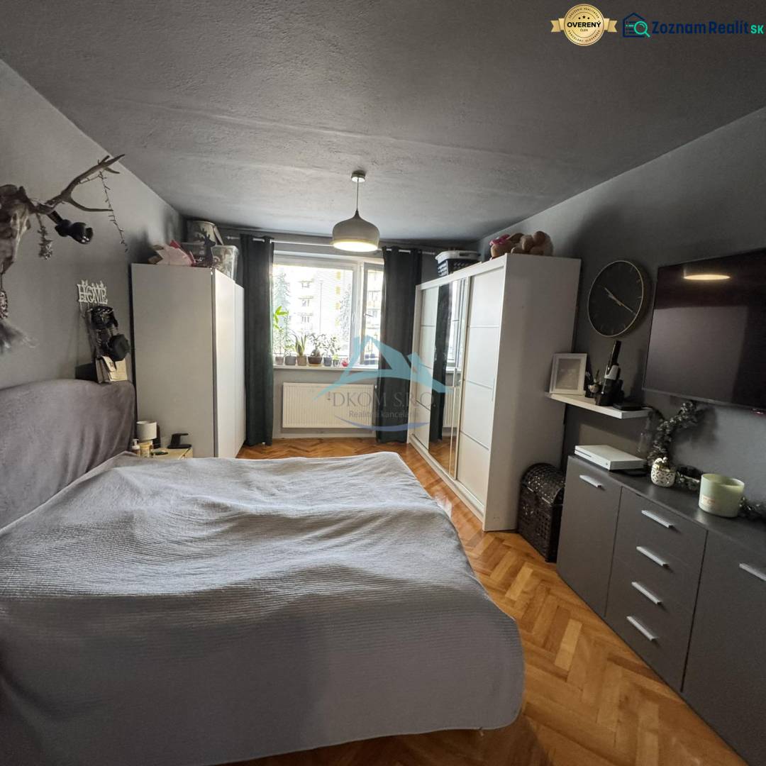 A bedroom in a 3-room apartment with a wardrobe, bed, and wooden decor flooring.