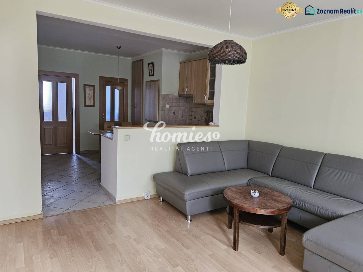 Living room with a corner sofa and a wooden decor floor in a 3-room apartment.
