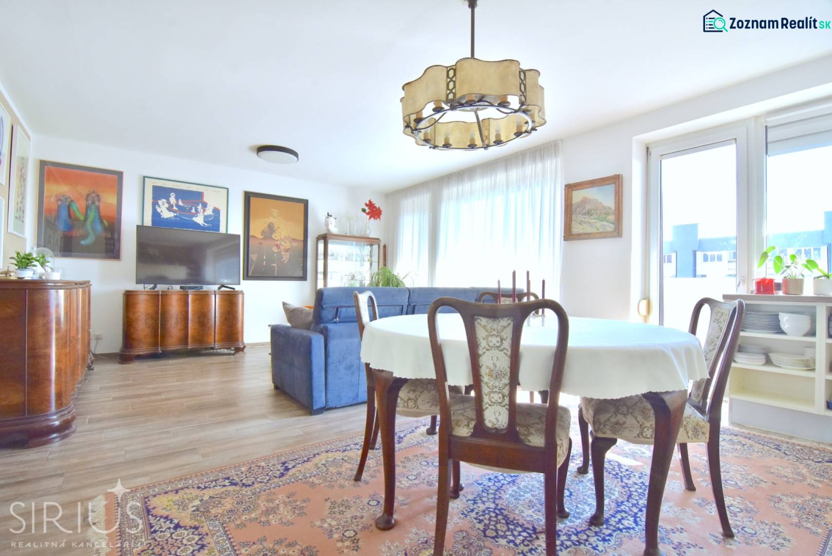 Living room with a dining table, sofa, and wood-patterned flooring in a 3-room apartment.