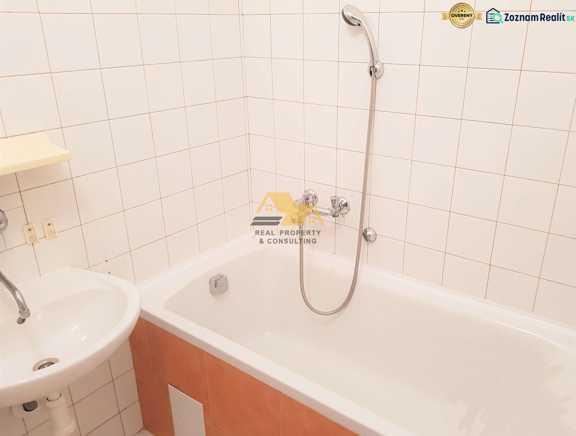 Bathroom in a 3-room apartment with a bathtub, sink, tiled with white tiles.