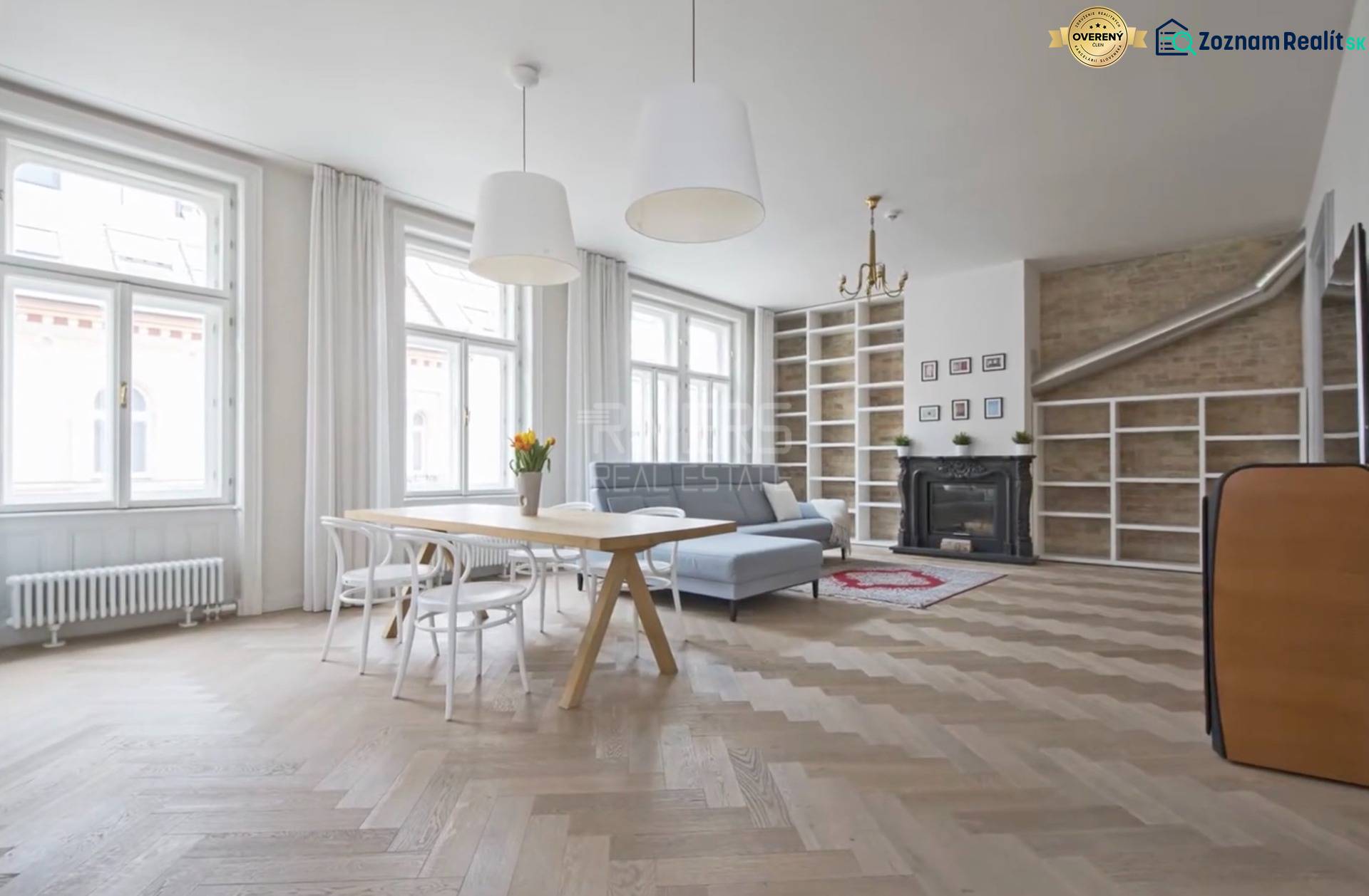 Spacious living area in a 4-room apartment with a fireplace and wood-patterned flooring.