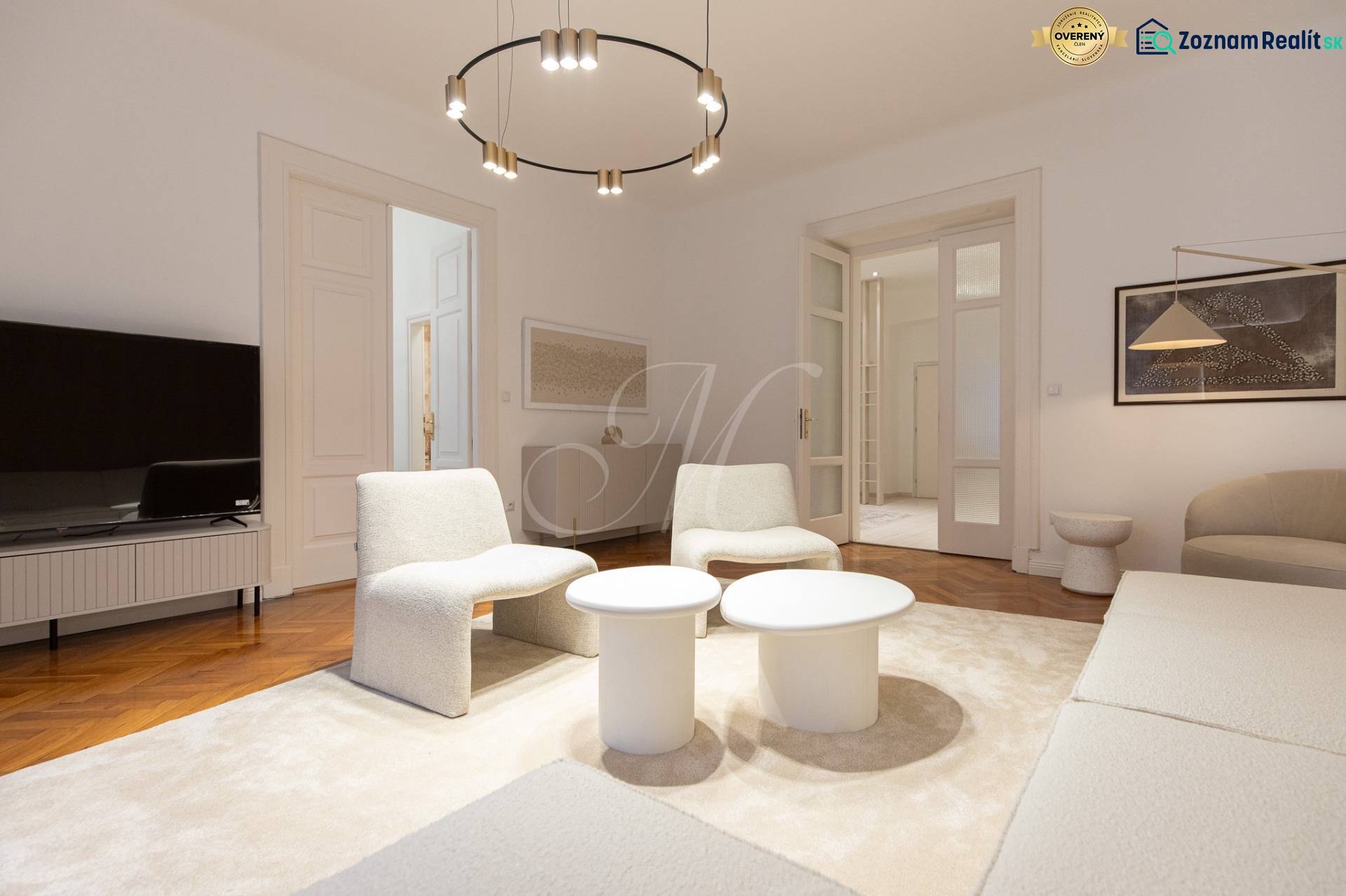 Living room in a 3-room apartment with white furniture and a wooden decor floor.