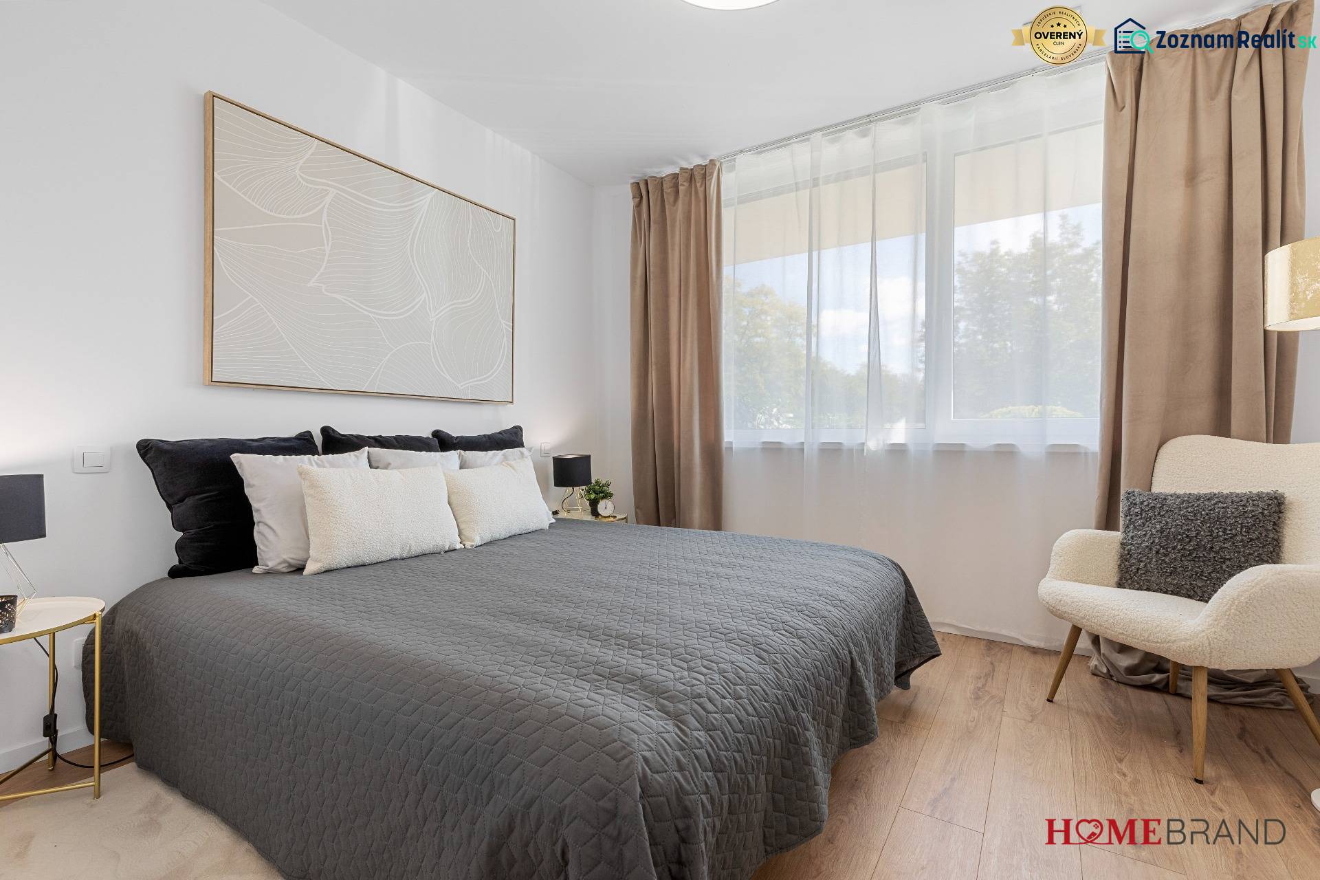 A bedroom in a 3-room apartment with a bed, an armchair, and a wooden decor floor.