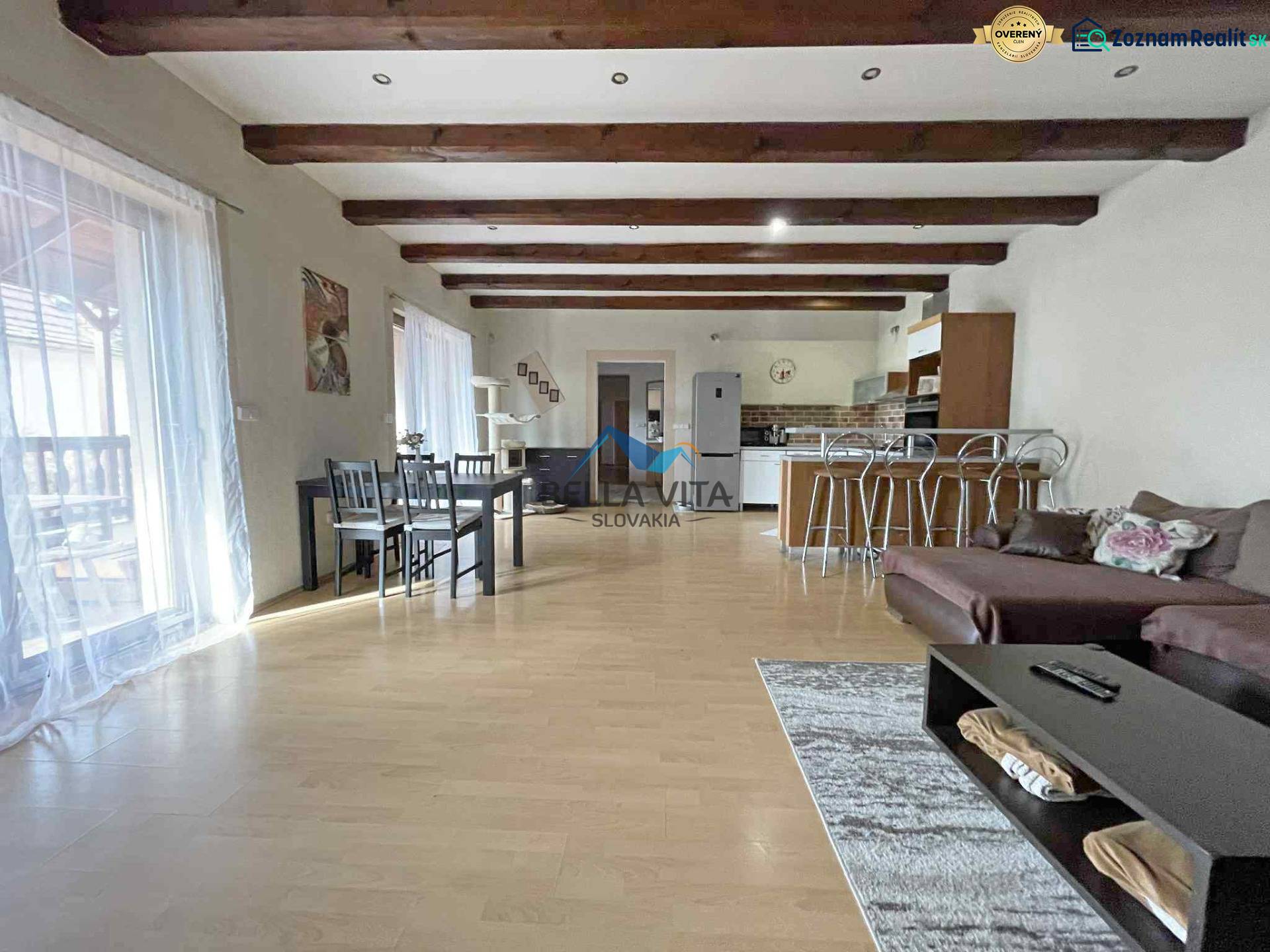 A family house with a wooden decor floor, a dining table, and a sofa set.