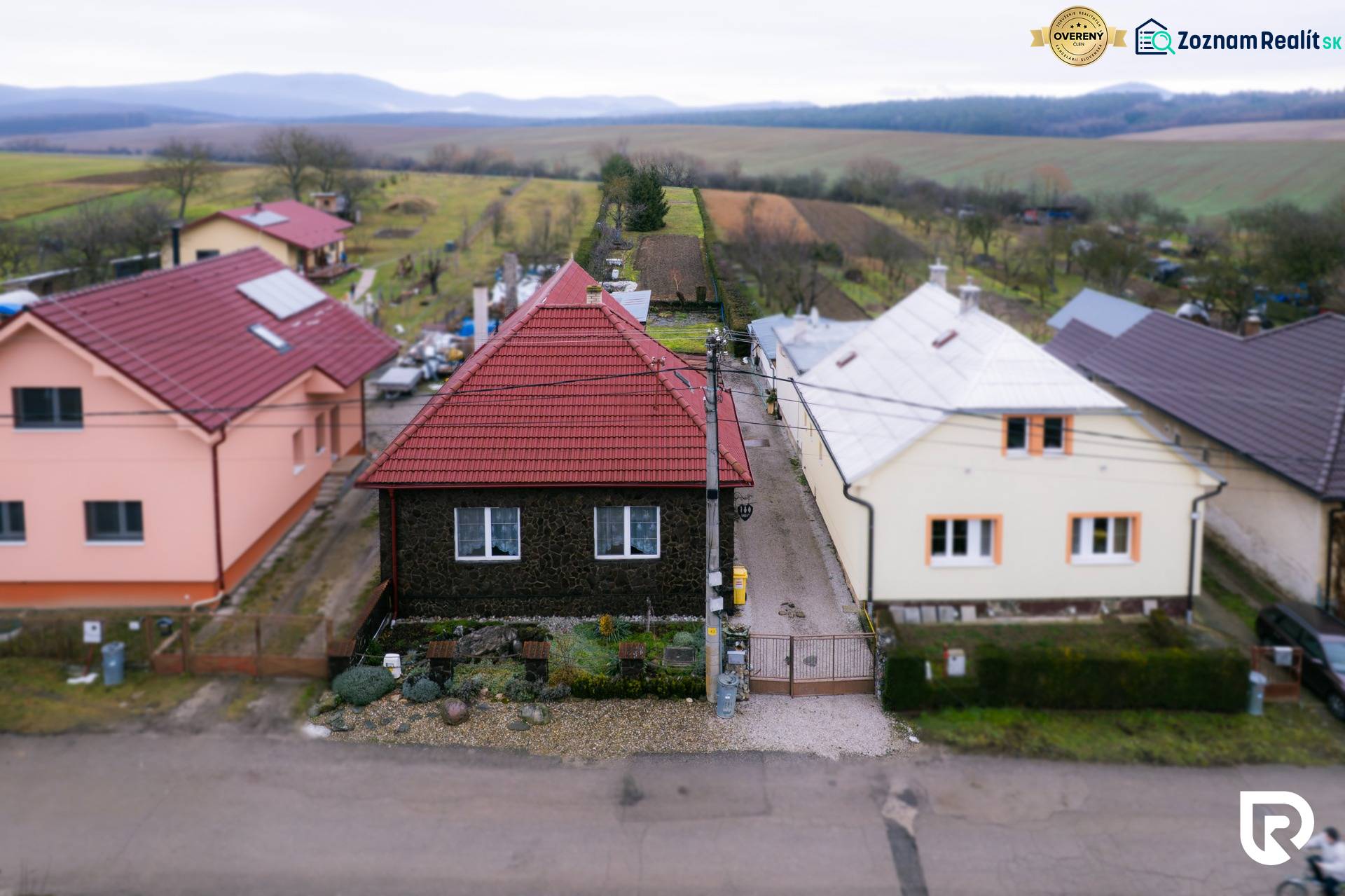 A family house on the street in Bobota with a view of fields and mountains.