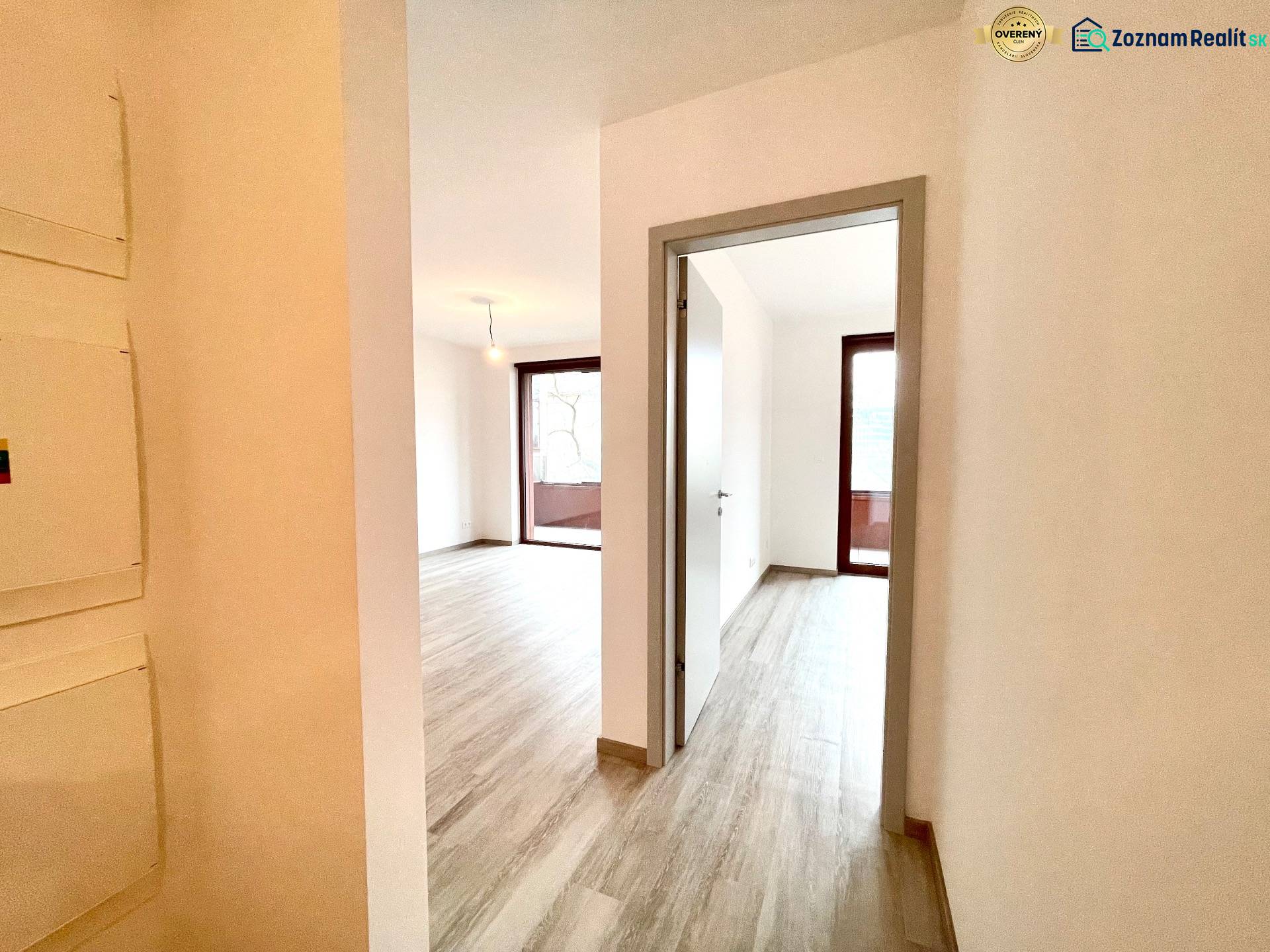 A hallway in a 2-room apartment with a wooden decor floor and light-colored walls.