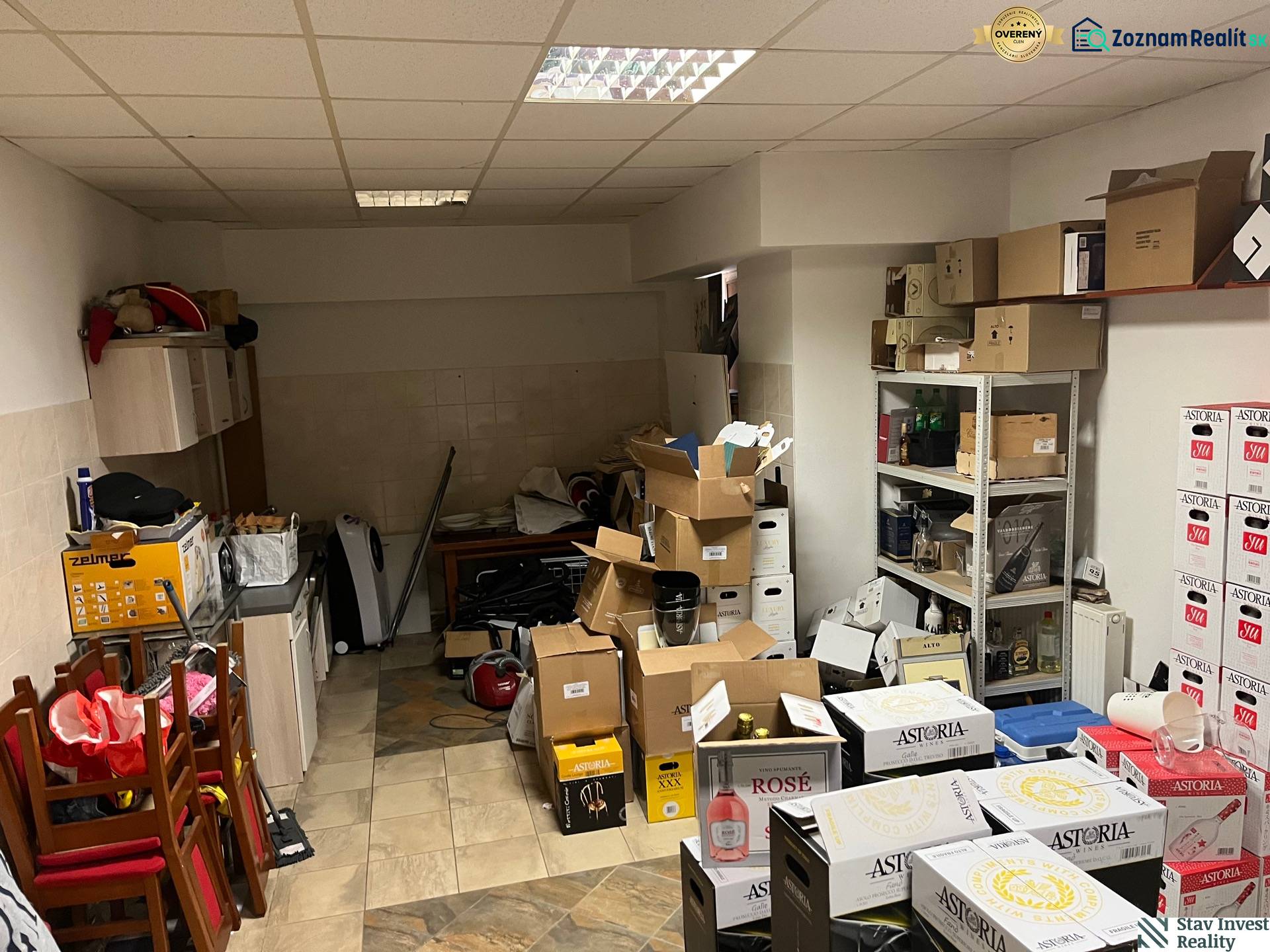 Commercial space with cardboard boxes, furniture, and shelves, wooden decor flooring.