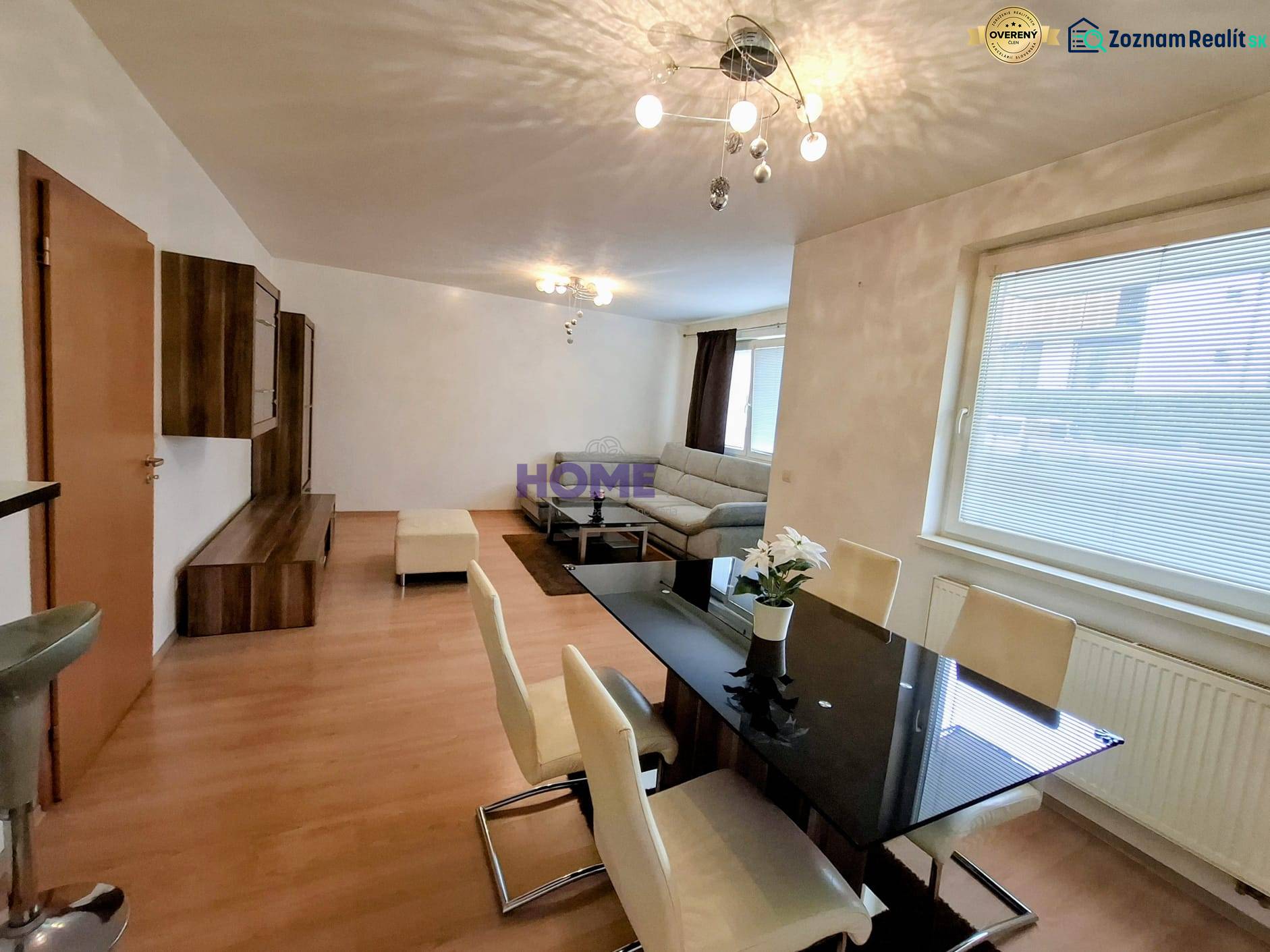 Dining and living area of a 3-room apartment with a wooden decor floor.