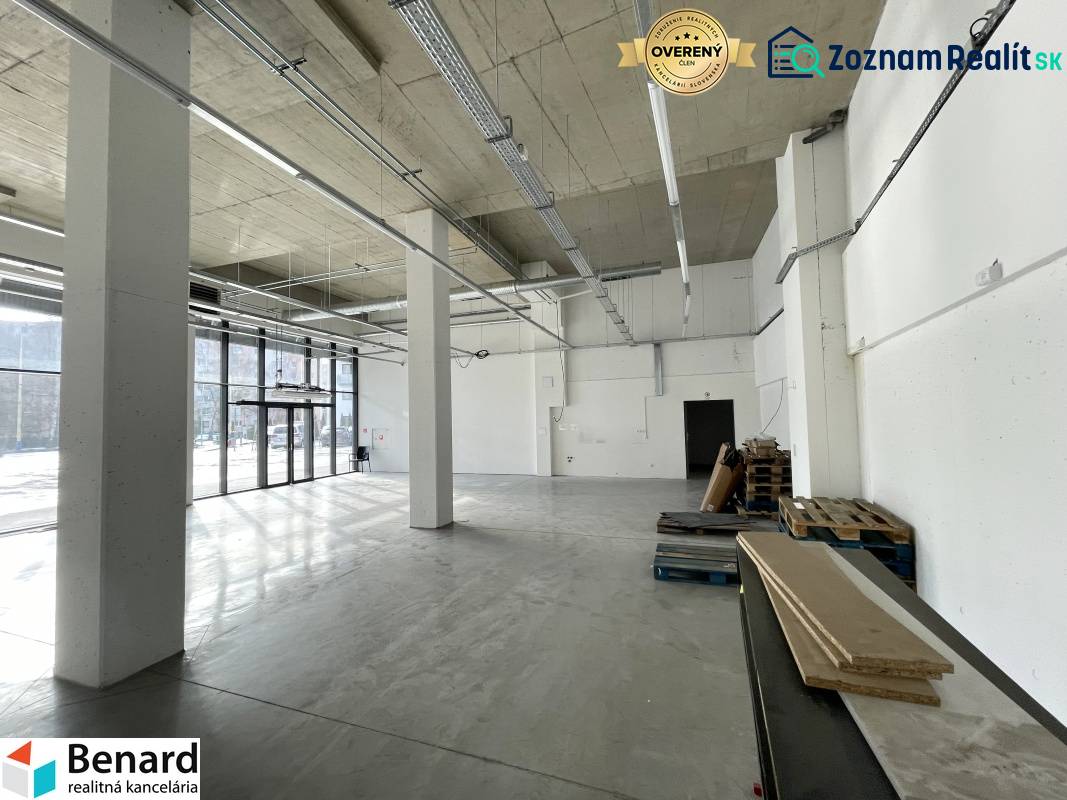 Spacious commercial spaces with large windows and high ceilings, flooring with wood decor.