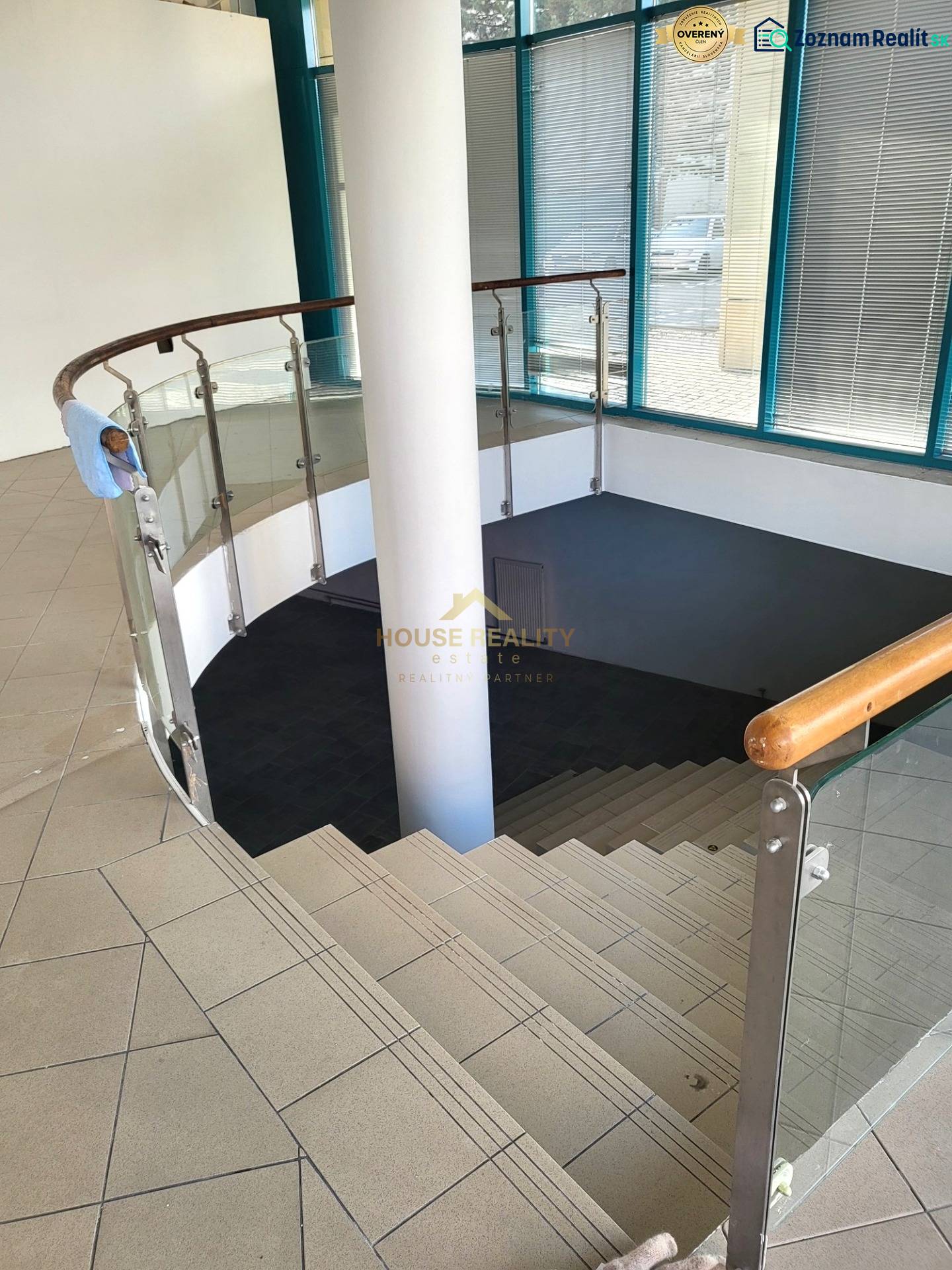 A staircase with glass railing leads to the lower part of the commercial premises.