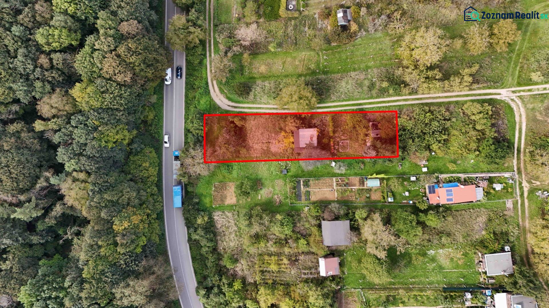 Aerial view of a garden cottage in Hlohovec surrounded by greenery and a road.