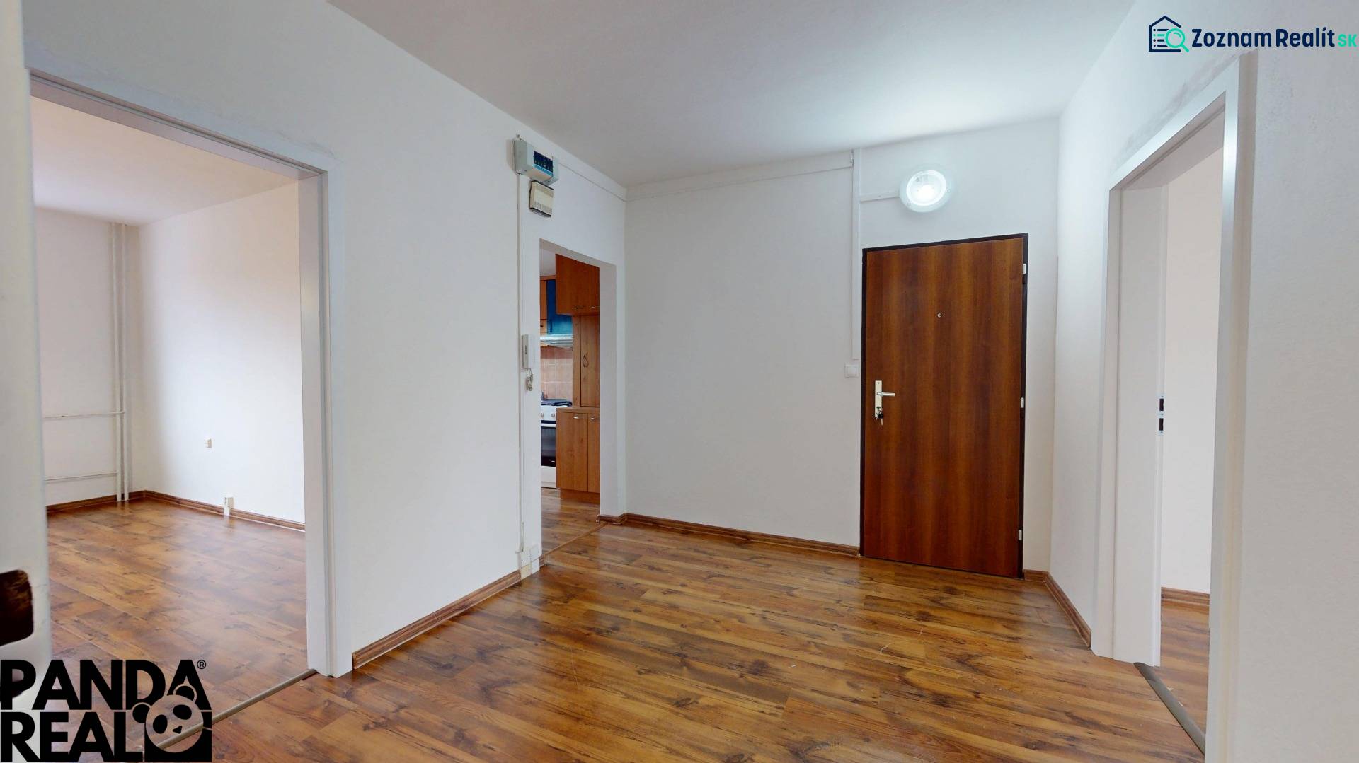 Interior of a 3-room apartment with a wooden decor floor and simple furnishings.