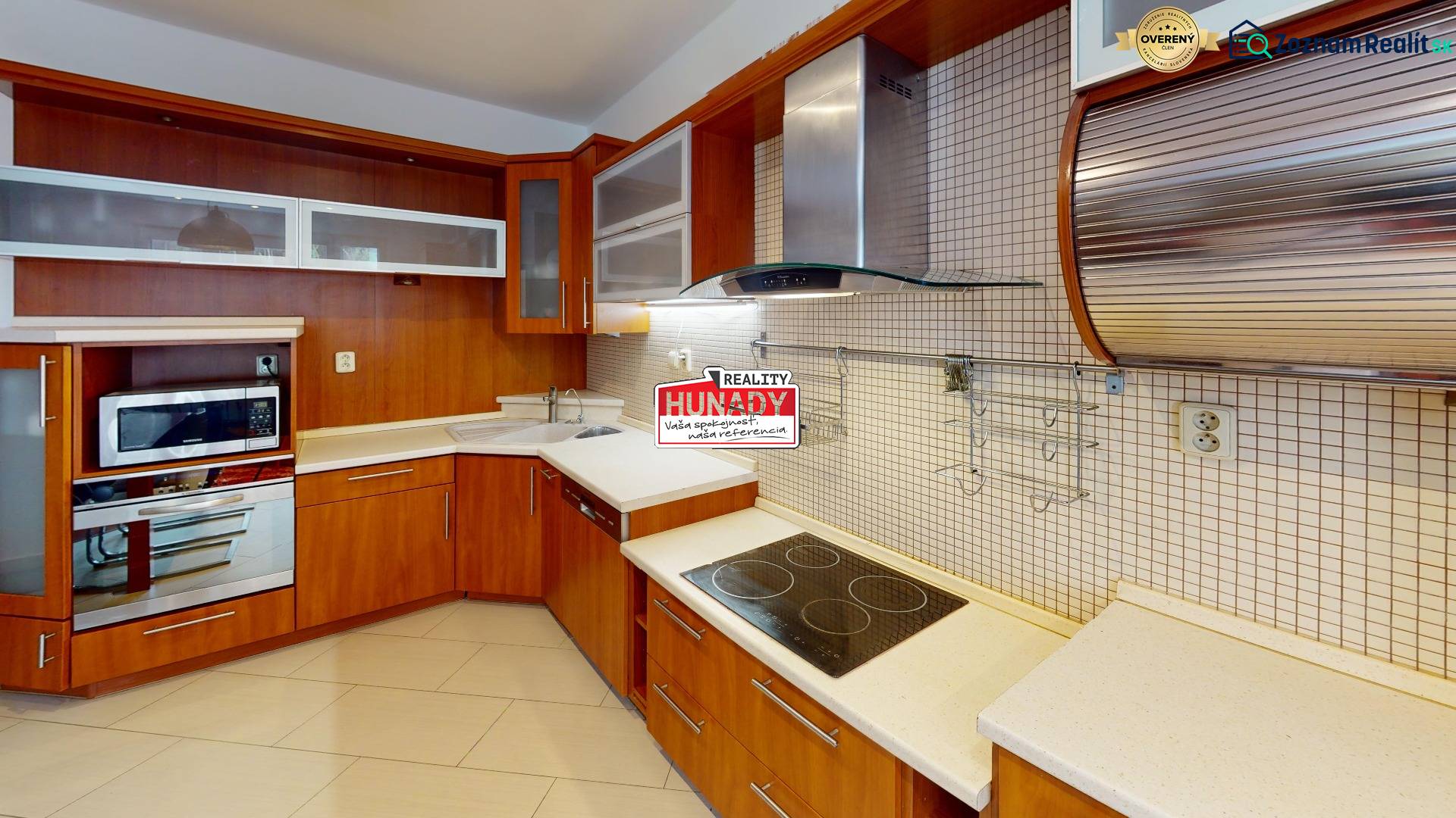 A kitchen in a 3-room apartment with a wooden decor kitchen unit and built-in appliances.