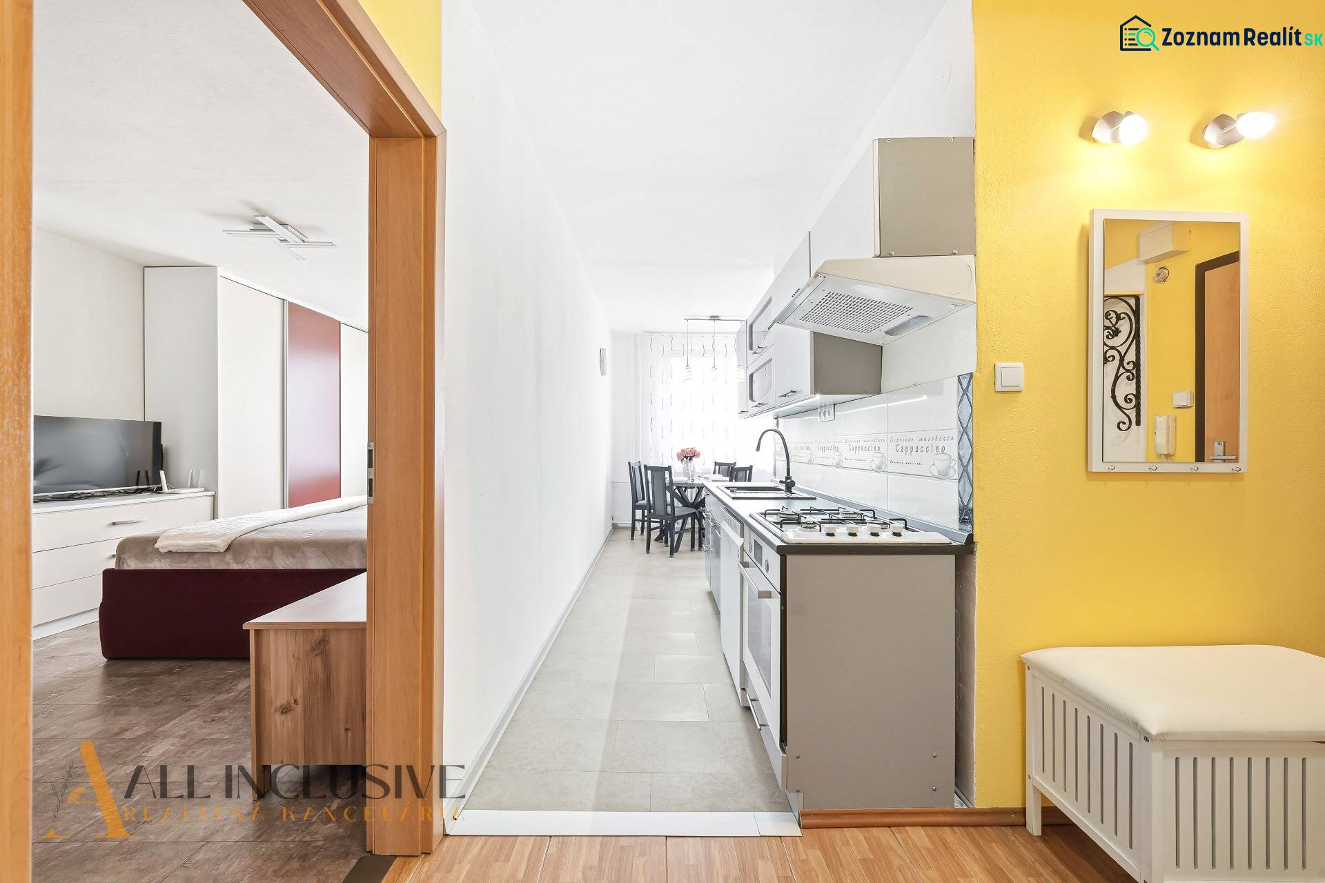 Interior of a 3-room apartment with wood-patterned flooring, kitchen, and bedroom.